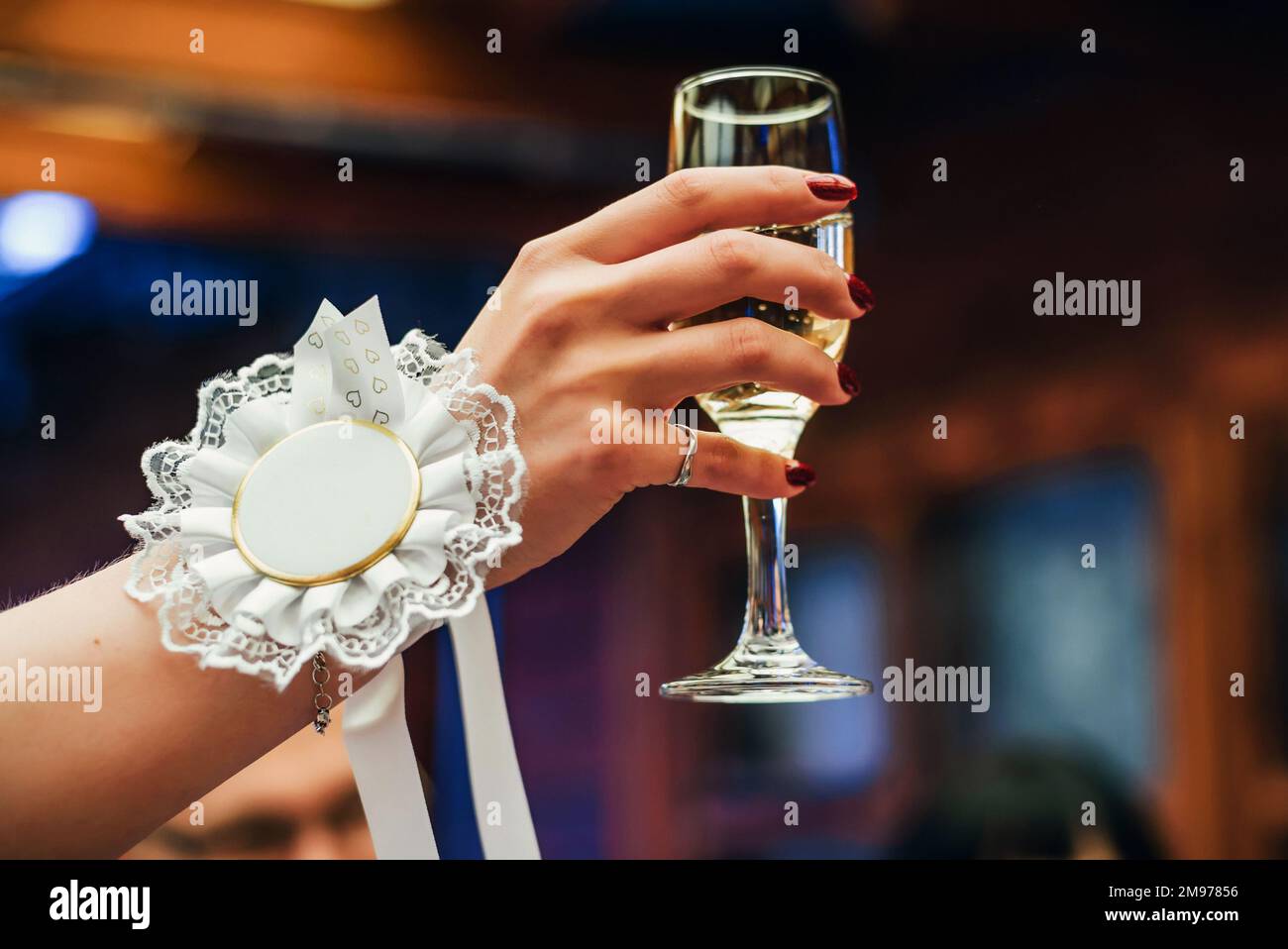 la main d'une femme lève un verre de champagne en vacances Banque D'Images