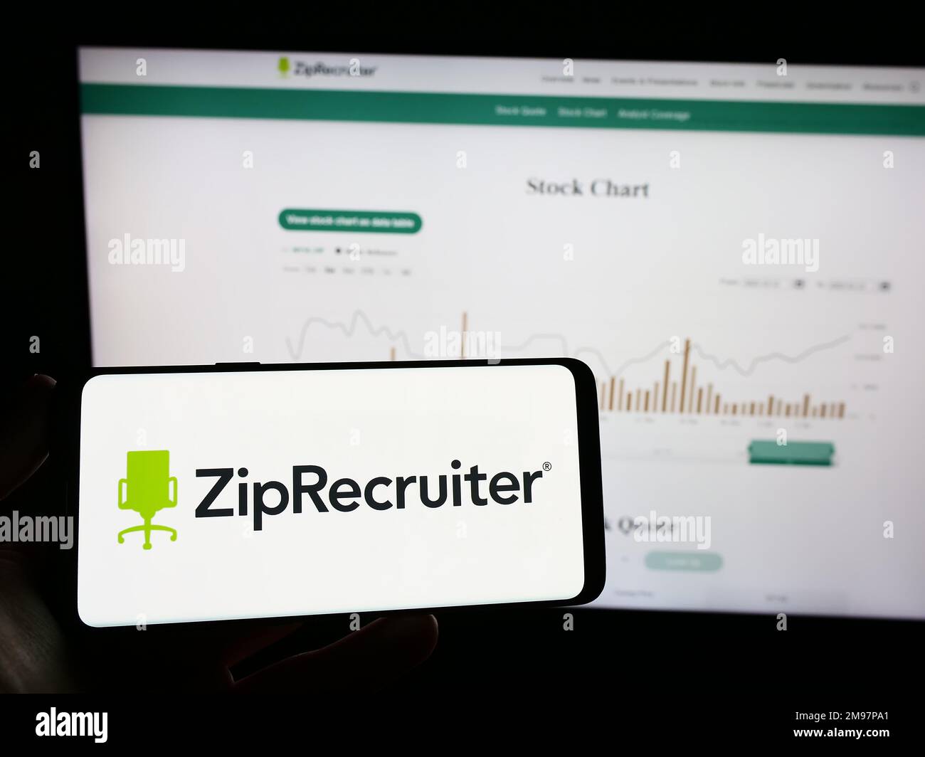 Personne tenant un téléphone mobile avec le logo de la société American Job Platform ZipRecruiter Inc. À l'écran en face de la page Web. Mise au point sur l'affichage du téléphone. Banque D'Images