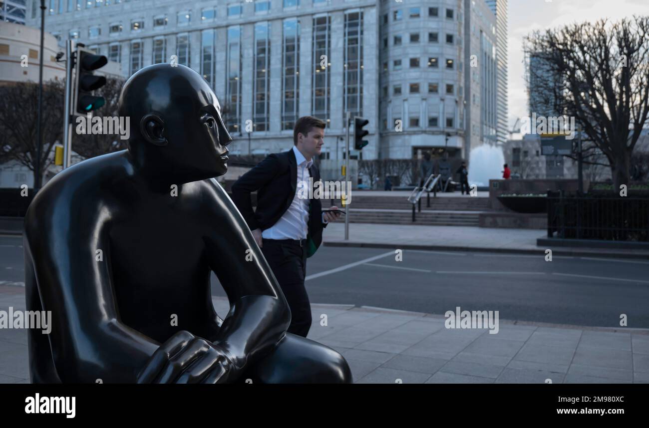Londres - 01 26 2022 : gros plan de la sculpture en bronze « Two Men on a Bench » de Giles Penny et Cabot Square en arrière-plan Banque D'Images