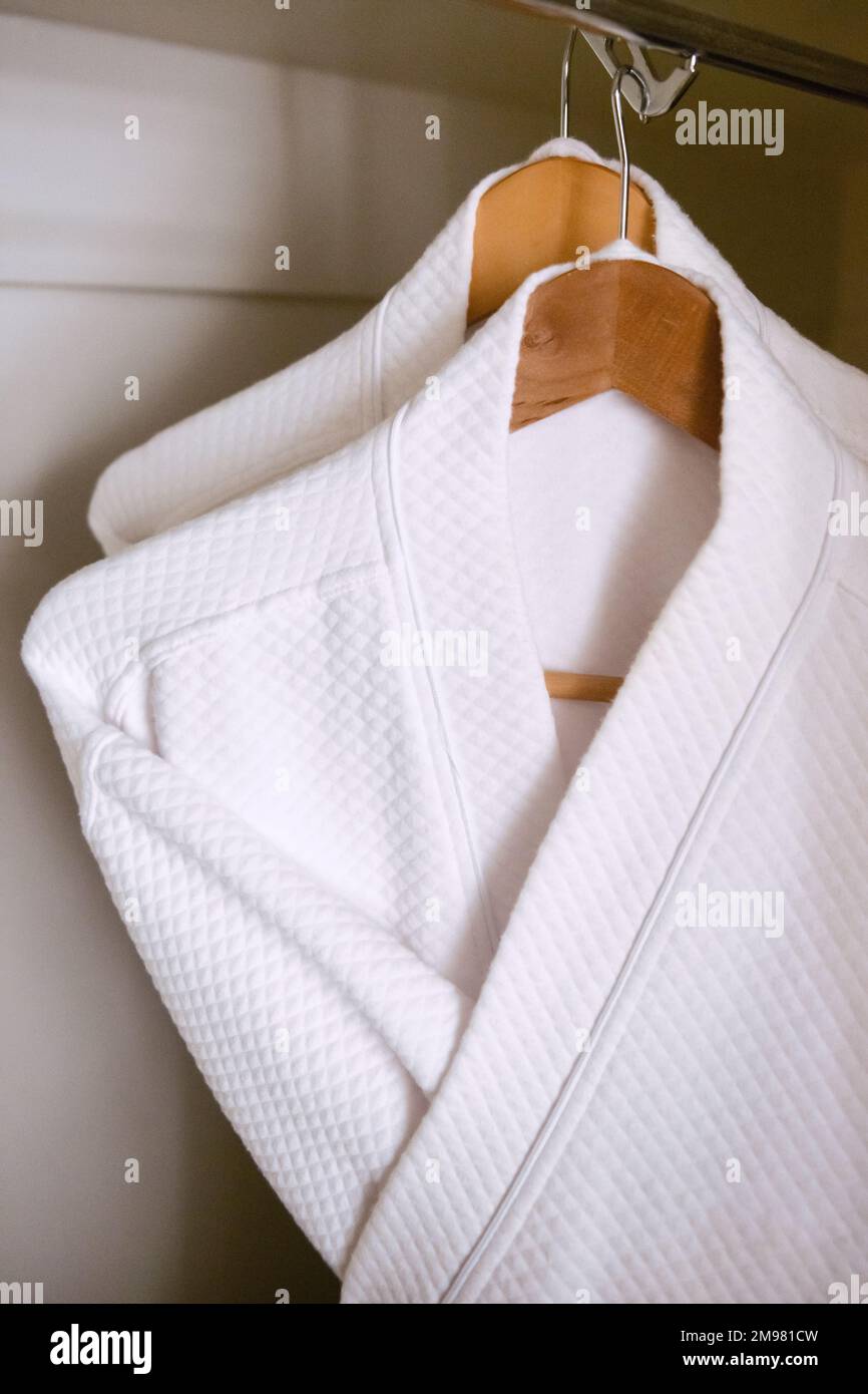 Gros plan de deux robes de chambre blanches suspendues dans une armoire Banque D'Images