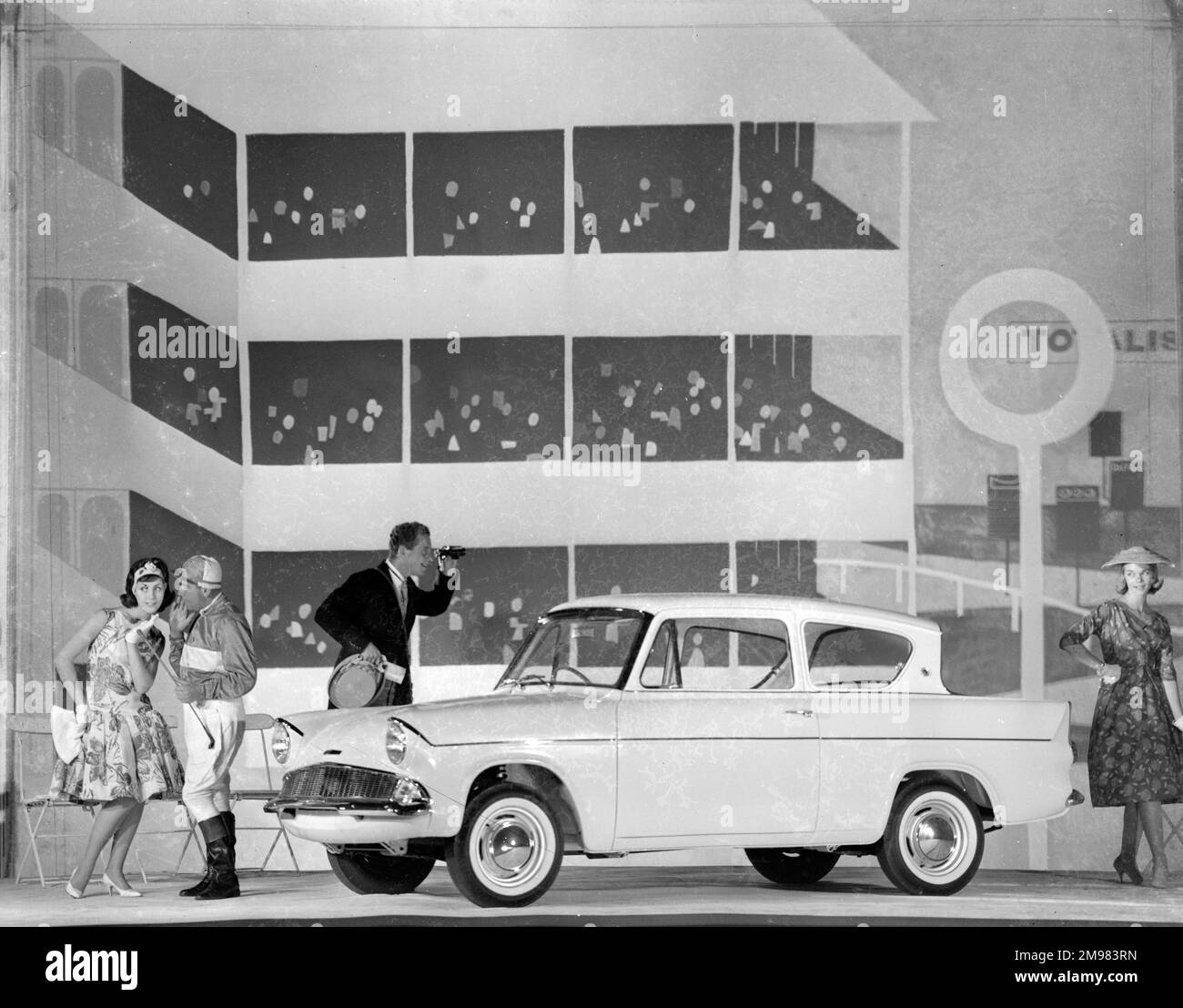 Publicité pour Ford Anglia cars -- modèles masculins et féminins posant (Geraldine Hill, Susan Ingram et Ossie O'Leary). Banque D'Images