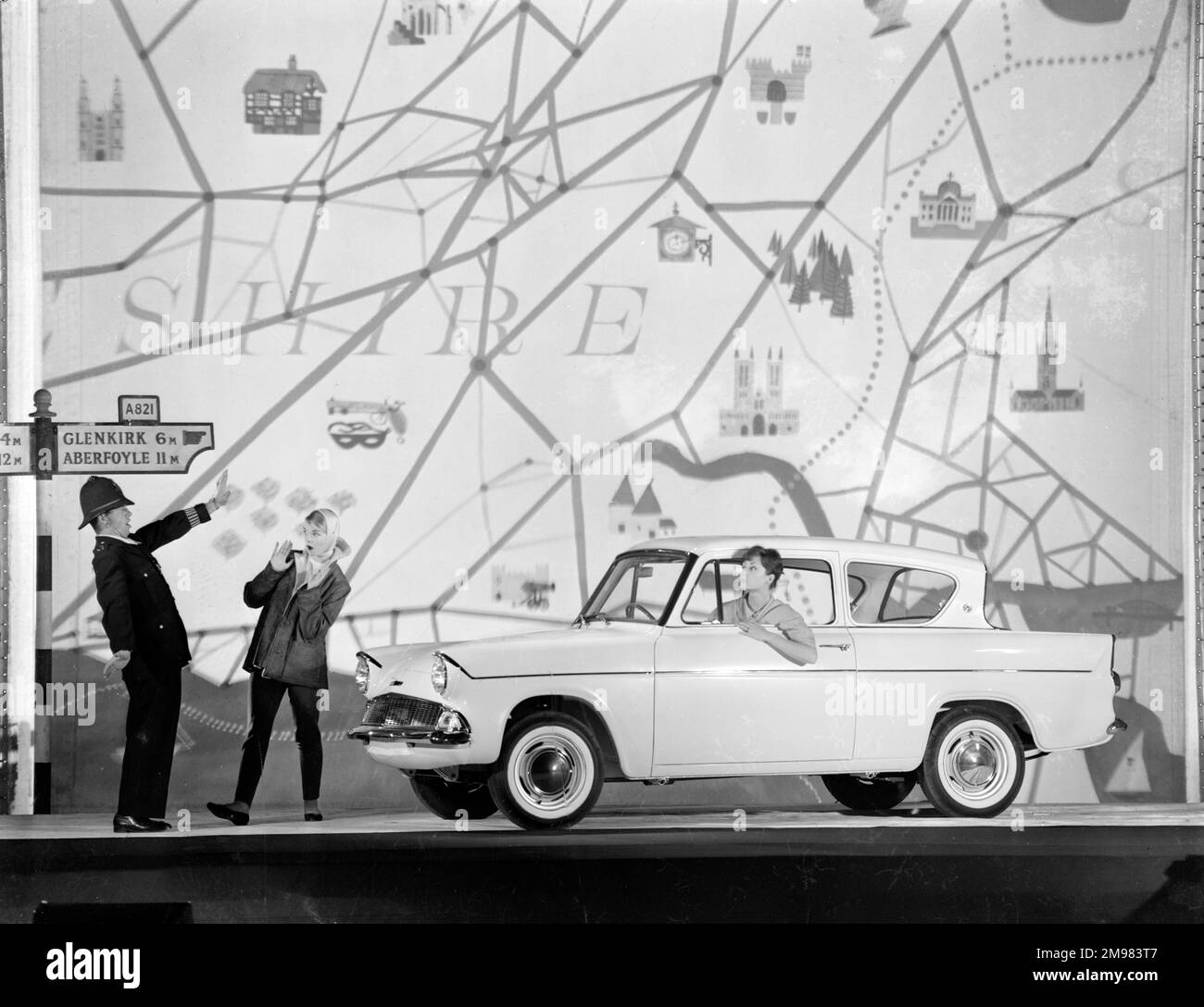 Publicité pour Ford Anglia cars -- modèles masculins et féminins posant (Geraldine Hill, Susan Ingram et Ossie O'Leary). Banque D'Images