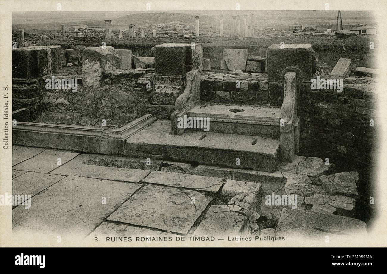 Les ruines de ce qui était autrefois Timgad, une ville coloniale romaine en Algérie, fondée par l'empereur Trajan vers 100AD. La ville est connue pour être l'un des meilleurs exemples de survie du plan de grille dans l'urbanisme romain, et a été saccagé par les Vandales au 5th siècle. Les latrines publiques sont visibles. Banque D'Images