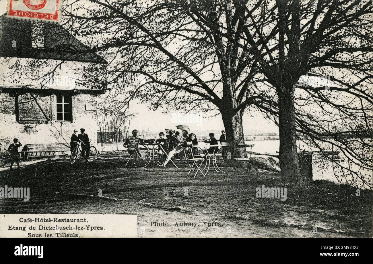 Hôtel près de l'étang à Dickebusch, sous les tilleuls (tous les Tilleuls). Les soldats et les randonneurs de jour devant un café, hôtel à côté de l'étang près d'Ypres. Enfants avec un vélo pose pour la photographie. La carte postale indique le restaurant du Cafe Hotel. Etang de Dickebusch-Lez-Ypres. Banque D'Images