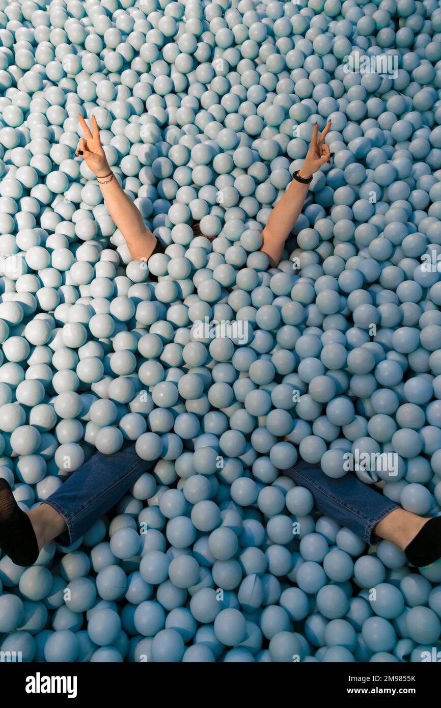 Vue en hauteur d'une femme jouant dans un ballon rempli de boules bleues en plastique Banque D'Images