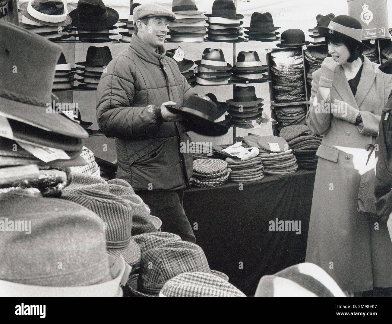 Vendeur de chapeau travaillant son charme dans un marché à Suffolk, Angleterre. Banque D'Images