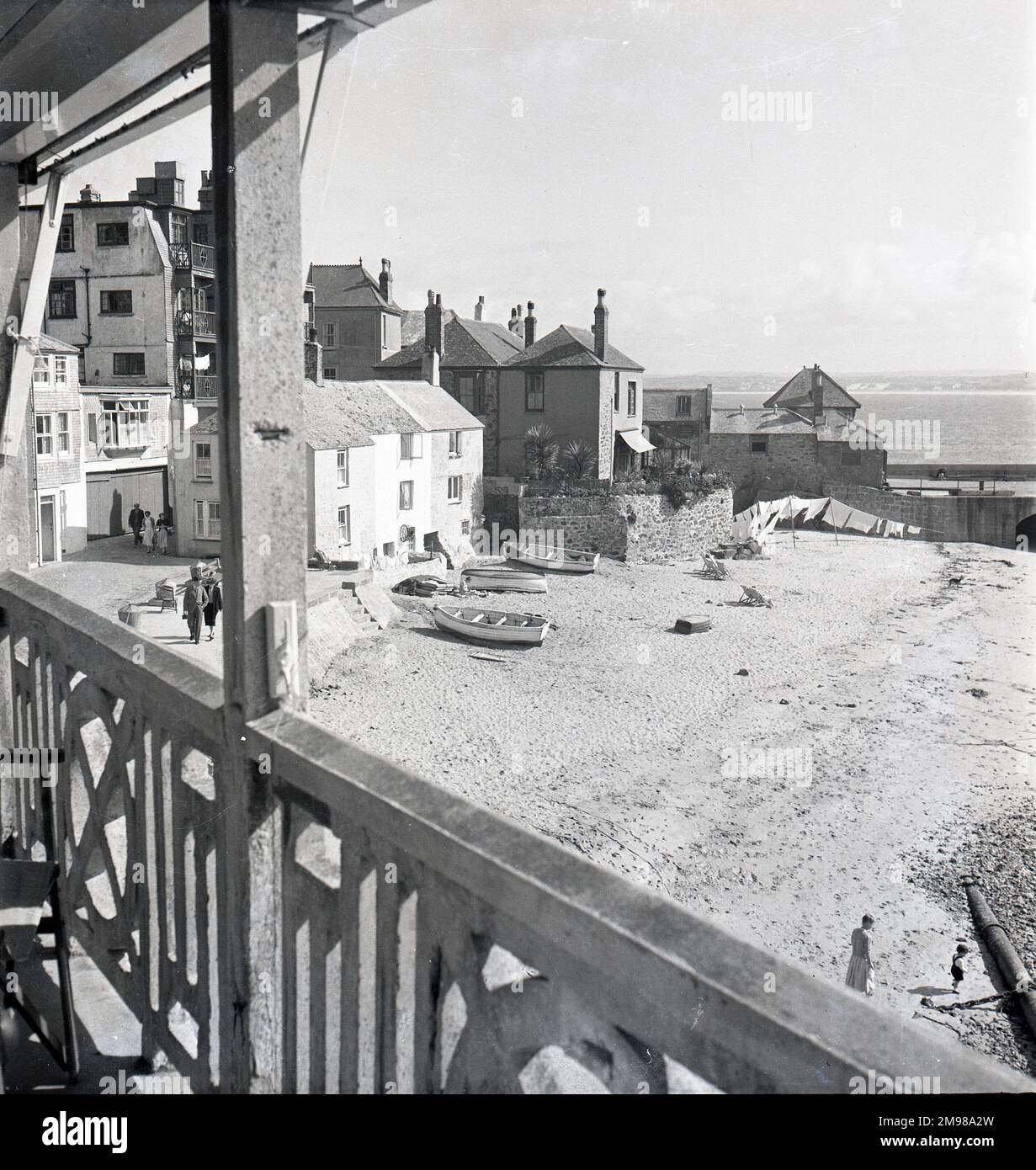 L'une des grandes séries d'études de St Ives, en Cornouailles. The Wharf & Quay Street depuis Seagull Flats, le matin. Le Harbour Beach Foresand, cottages & Quay House, St Leonard's Chapel, le Pilot's Office (aujourd'hui le Harbour Master's Office), pante sur la plage et sèche-linge, donc c'est probablement lundi. En bas à droite se trouve le grand tuyau d'égout au bas du petit collecteur de Curnow. Banque D'Images