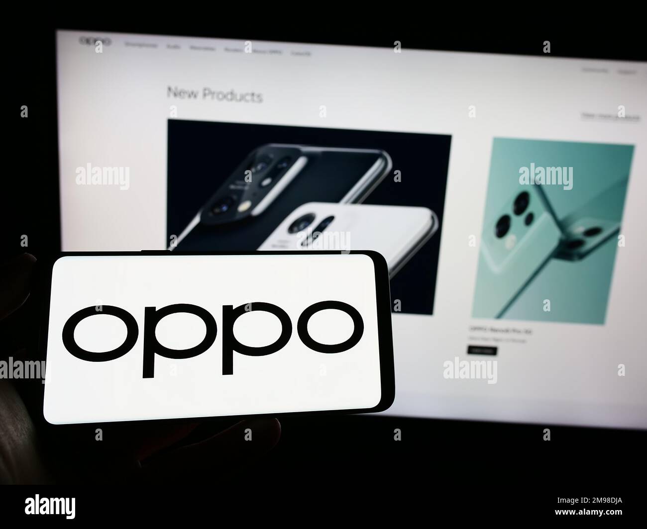 Personne tenant un smartphone avec le logo de la société chinoise d'électronique grand public OPPO à l'écran devant le site Web. Mise au point sur l'affichage du téléphone. Banque D'Images