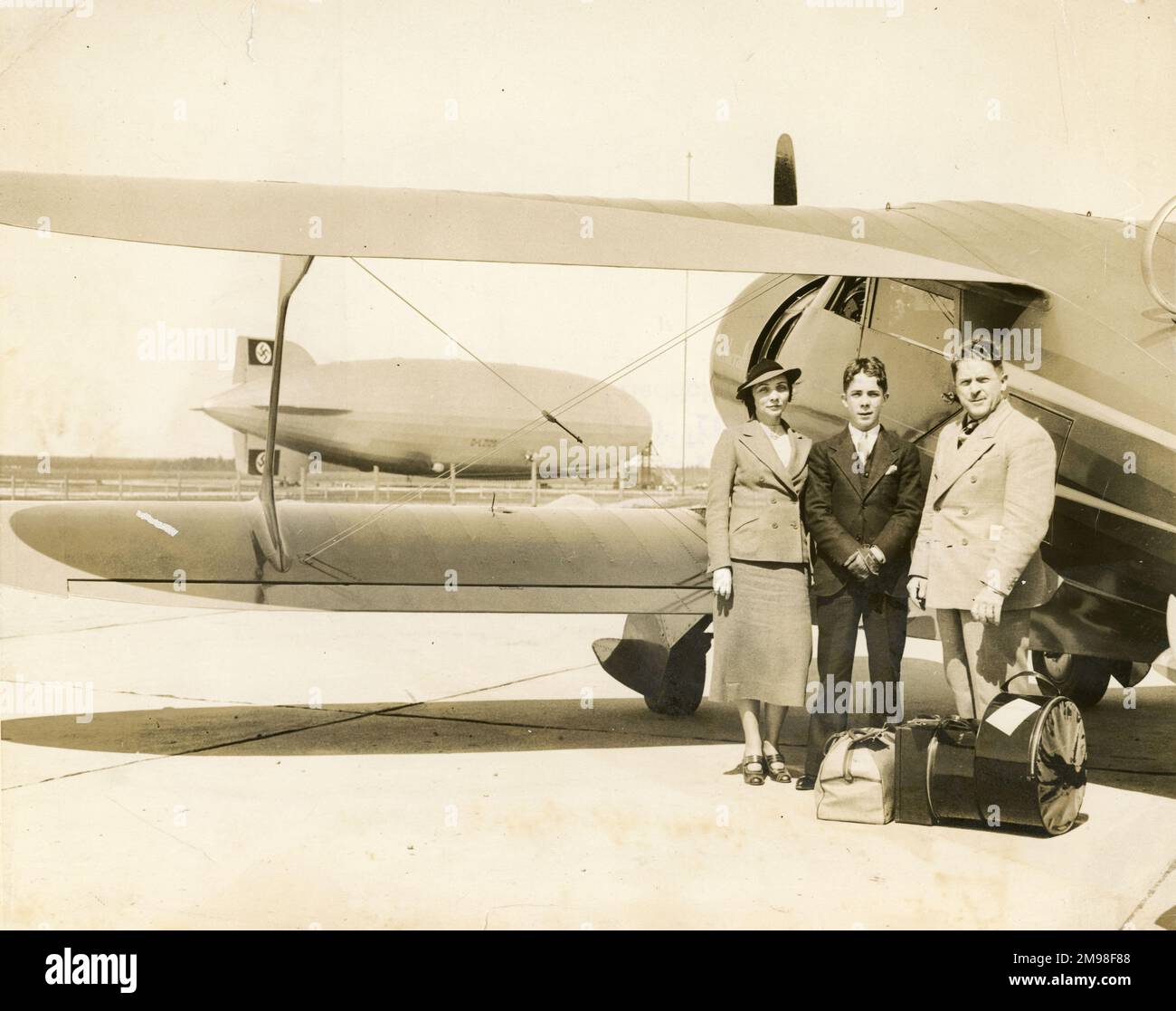James et Mary ?Mae ? Haizlip avec leur fils James Jr à côté de leur Beechcraft Model 17 Stagerwing à Lakehurst, New Jersey, avant leur vol vers l'Europe à LZ 129 Hindenburg le 11 mai 1936. L'avion a également été transporté sur ce vol. Banque D'Images