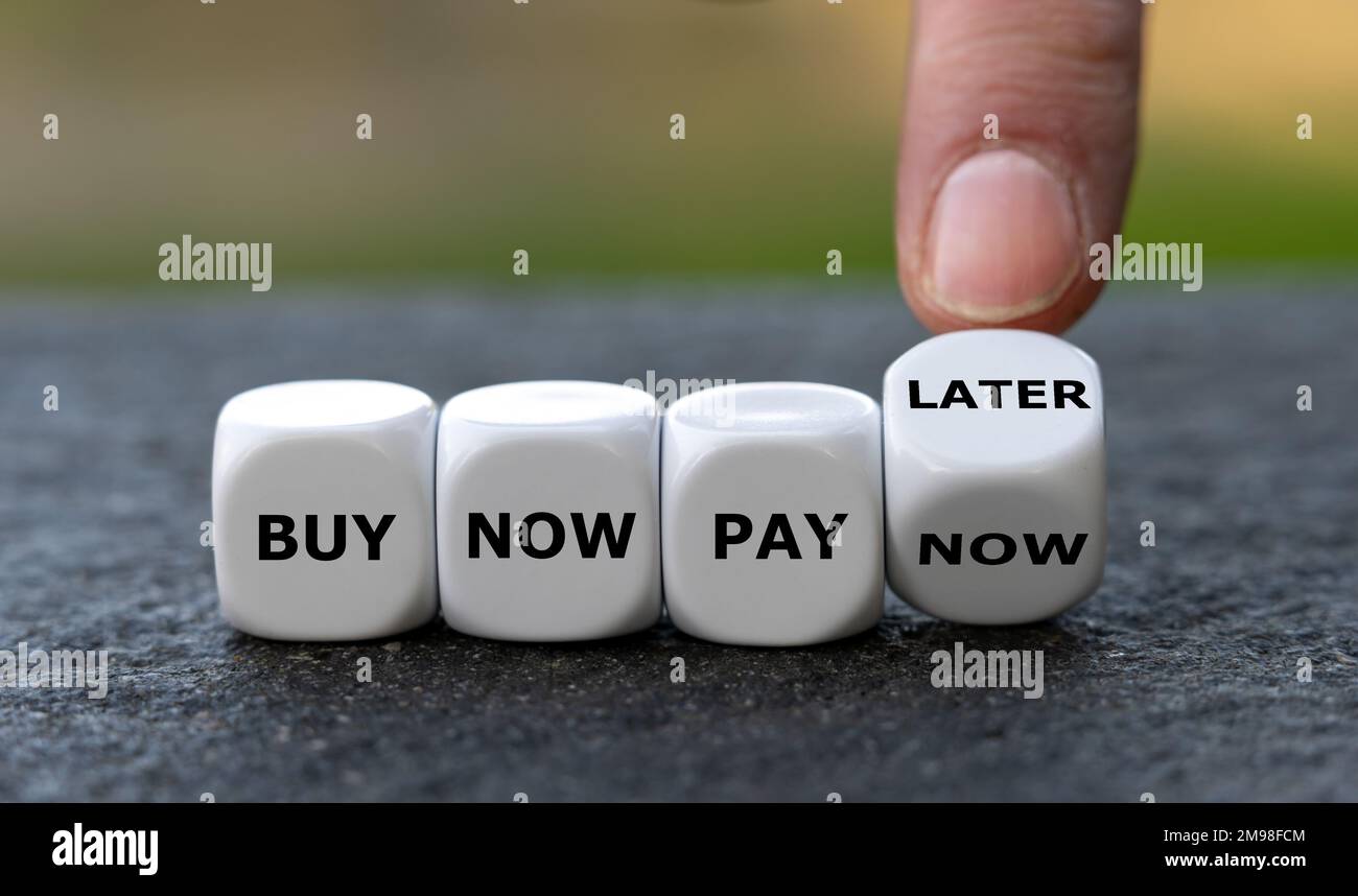La main tourne les dés et change l'expression « acheter maintenant payer maintenant » pour « acheter maintenant payer plus tard ». Banque D'Images