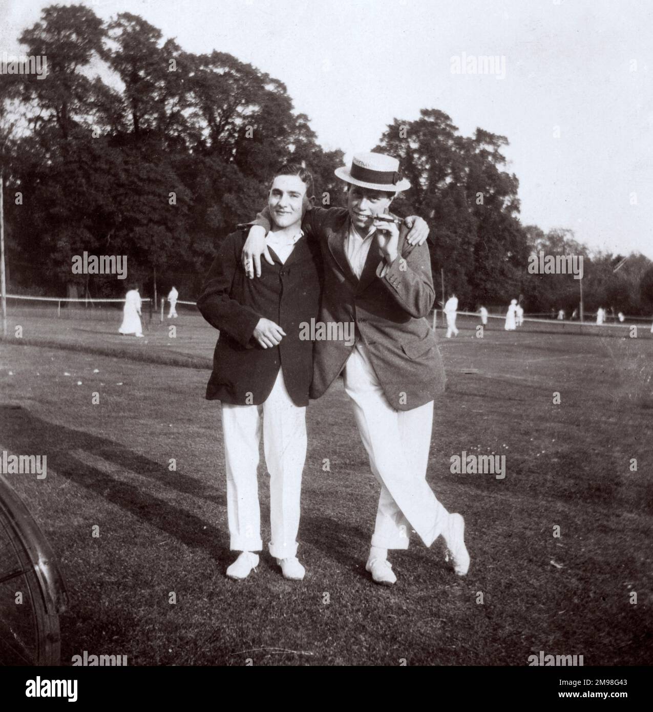 Deux jeunes hommes (Harold Auerbach et Raymond Squire) au Hanger Hill tennis Club, Ealing, West London, avec des personnes jouant au tennis en arrière-plan. Banque D'Images