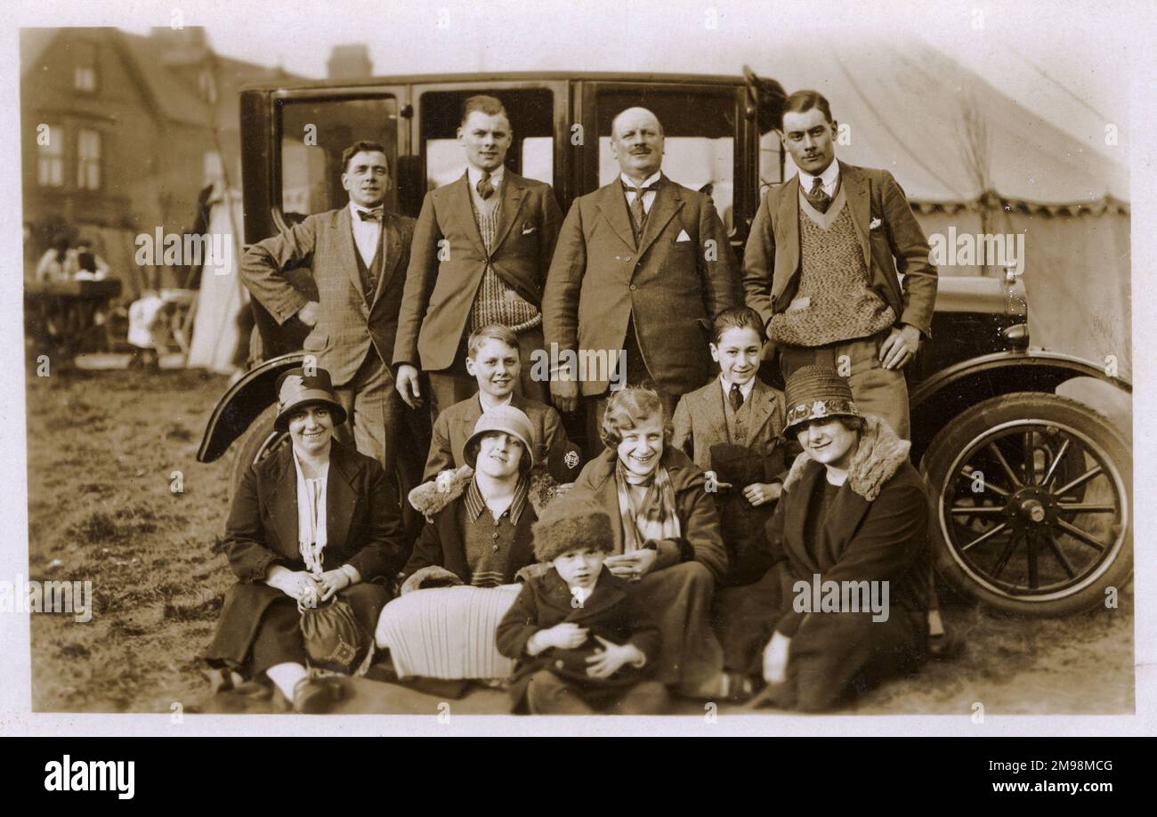 Groupe familial étendu (trois générations) à une foire locale (posant fièrement devant leur nouvelle voiture) - Manchester, Angleterre. Banque D'Images