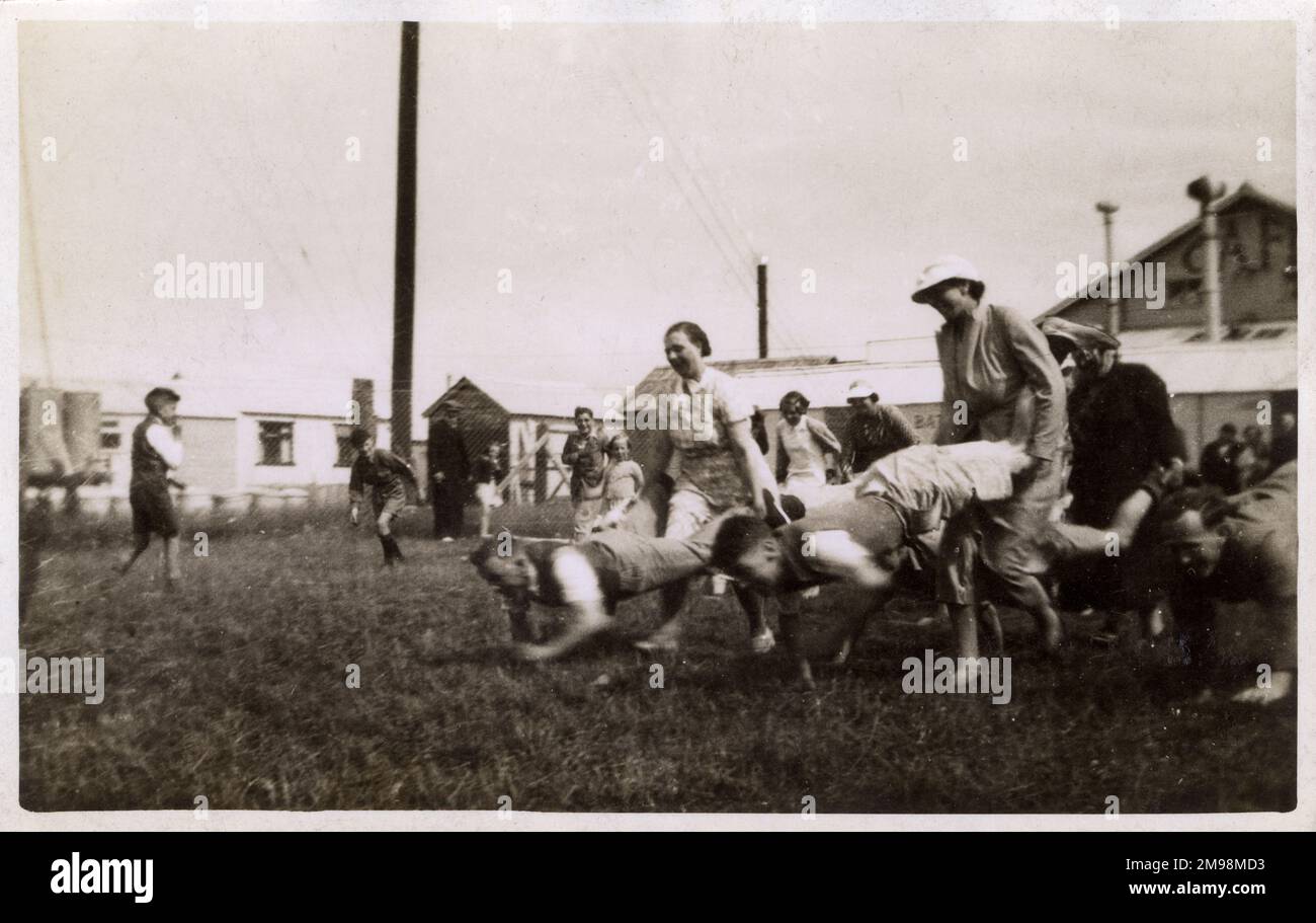 Course de brouettes dans un camp de vacances britannique. Au début du 20th siècle, les camps commençaient à être construits avec des logements en cabane. Banque D'Images