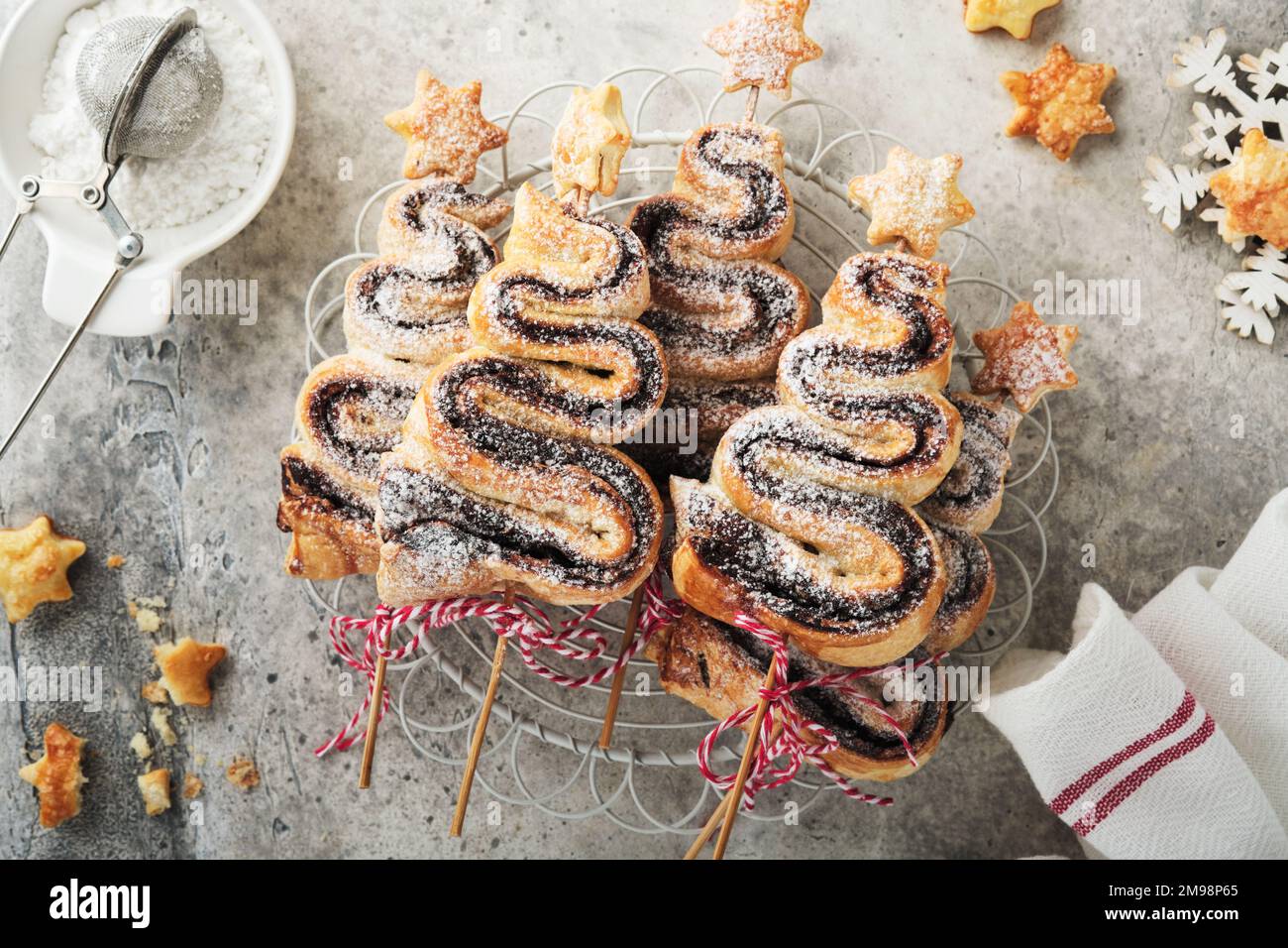 Gâteau feuilleté en forme d'arbre de Noël avec garniture au chocolat, poudre de sucre et sucettes sur fond de bois blanc ancien. Noël, nouvel an Banque D'Images