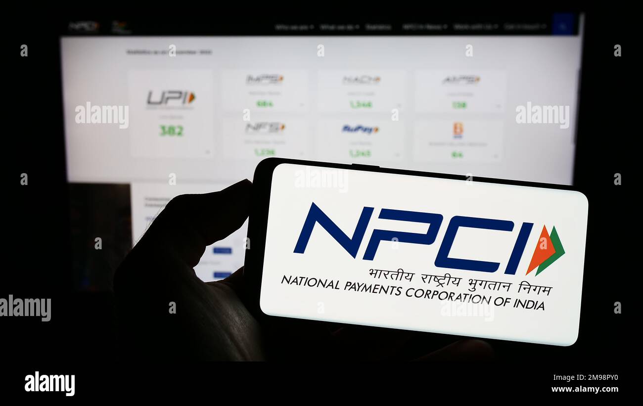 Personne tenant un téléphone portable avec le logo de la National Payments Corporation of India (NPCI) à l'écran devant la page Web. Mise au point sur l'affichage du téléphone. Banque D'Images