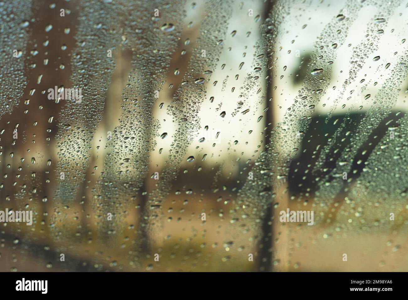 Gouttes d'eau sur la fenêtre du véhicule le jour de la pluie. Par la fenêtre de la voiture avec des gouttes de pluie sur le verre de la rue le jour sombre de l'automne Banque D'Images