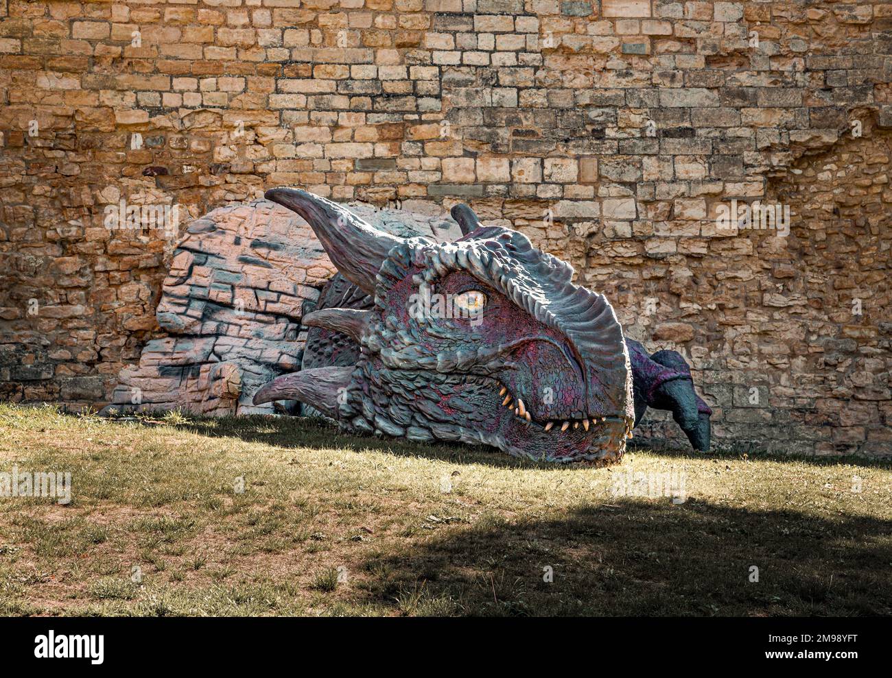 Lucy le dragon se brisant à travers un mur du château de Lincoln. Banque D'Images