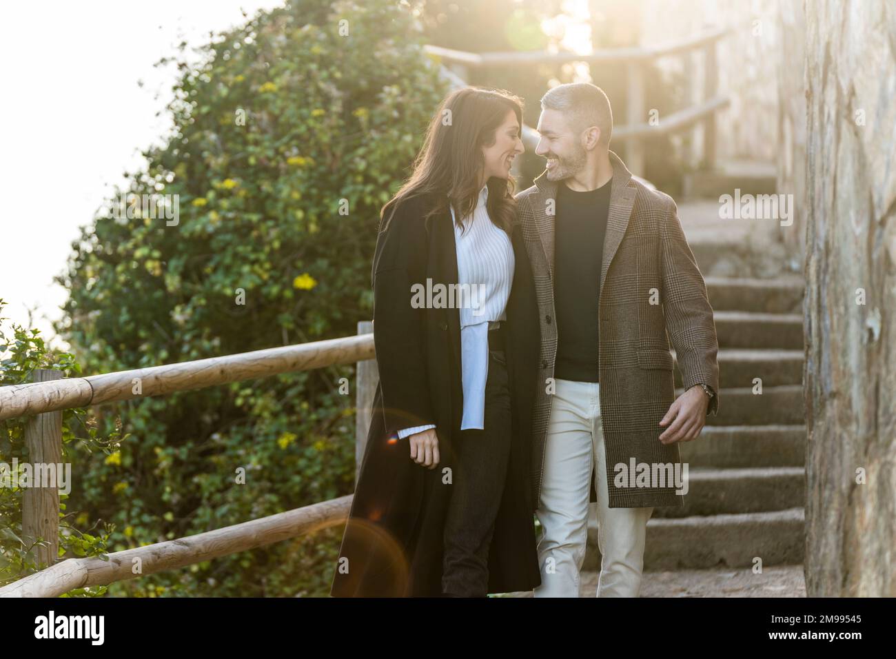 Un couple hétérosexuel marchant sur un chemin côtier en hiver Banque D'Images