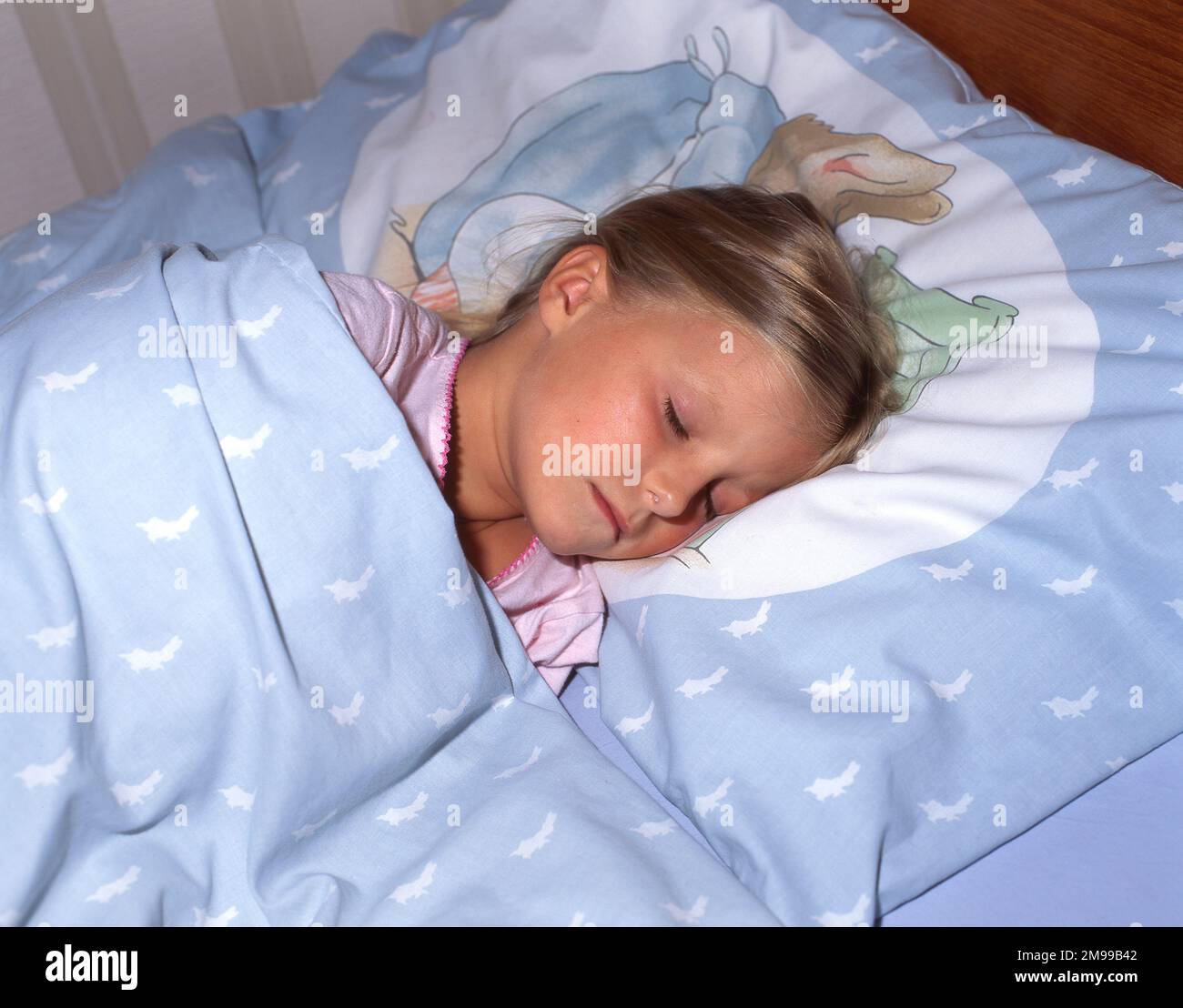 Jeune fille endormi dans le lit, Winkfield, Berkshire, Angleterre, Royaume-Uni Banque D'Images