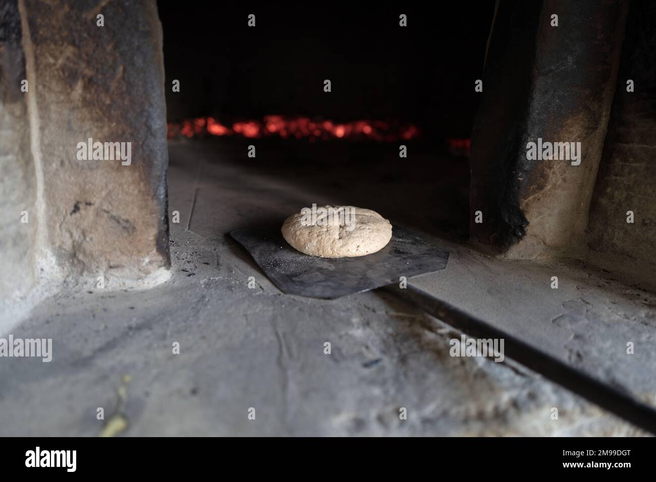 Le pain fait maison entre dans un four traditionnel en bois d'une maison de campagne de Toscane Banque D'Images