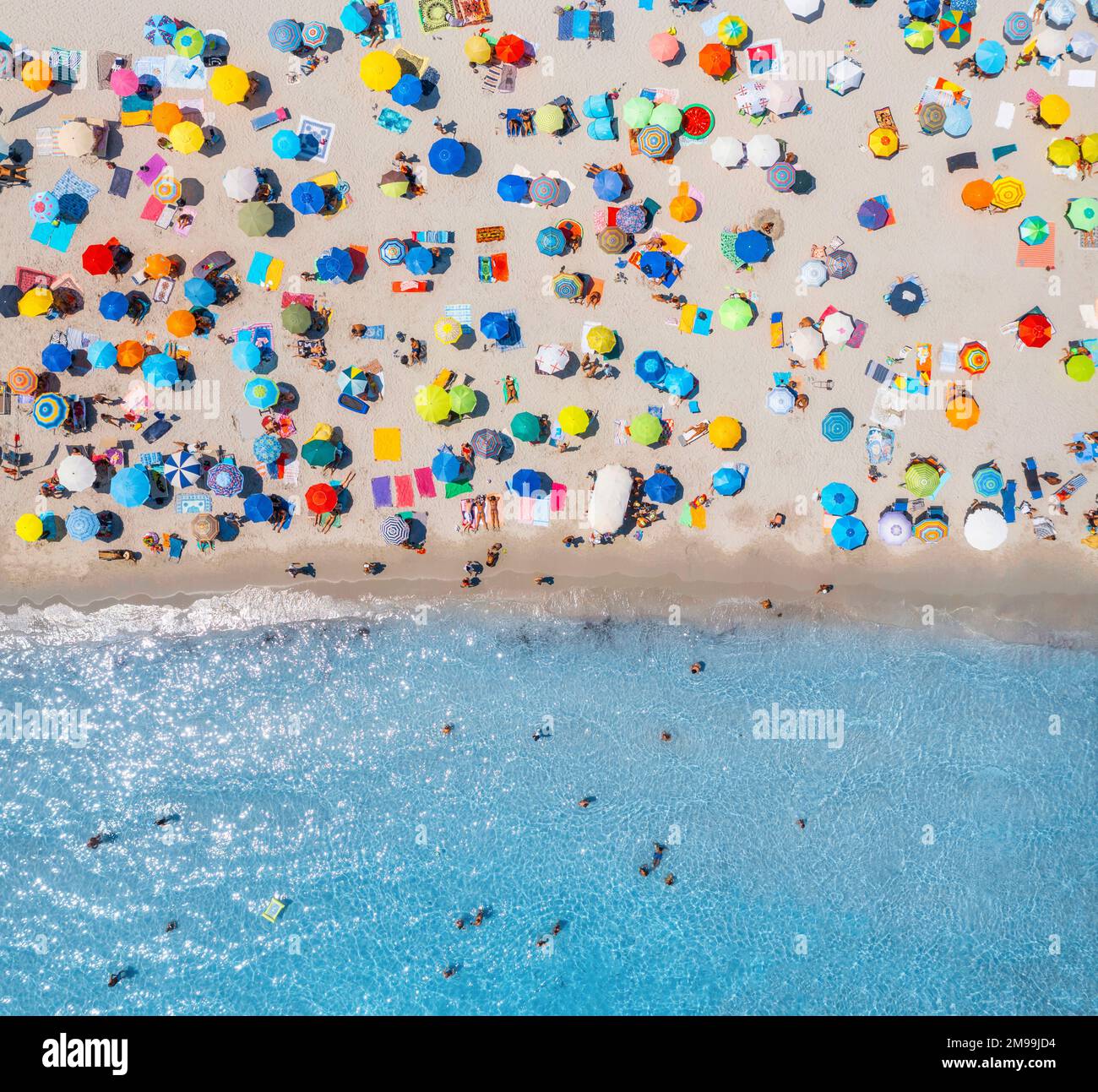 Vue aérienne des parasols sur la plage de sable, les gens en mer bleue Banque D'Images