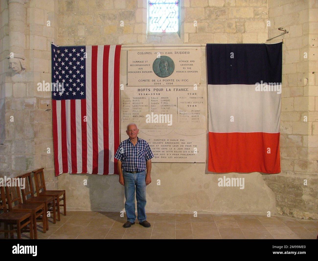 Cricqueville est juste derrière la Pointe du hoc où Texan Rudder a débarqué avec son bataillon des Rangers de 2nd. La figure sur la photo est l'ancien maire, Louis Devin, qui a élevé le Mémorial. La reconnaissance aérienne avait montré des structures en béton formidables sur la Pointe menant à la conclusion qu'elle contenait des canons de 155 mm qui pouvaient tirer le long des plages américaines. Une attaque des forces spéciales a été prévue pour sortir de la position le jour J et les Rangers, en montant les falaises abruptes de la petite plage en utilisant leurs poignards comme mains courantes, ont surpassé les Allemands seulement pour découvrir que les armes avaient été enlevées. Banque D'Images