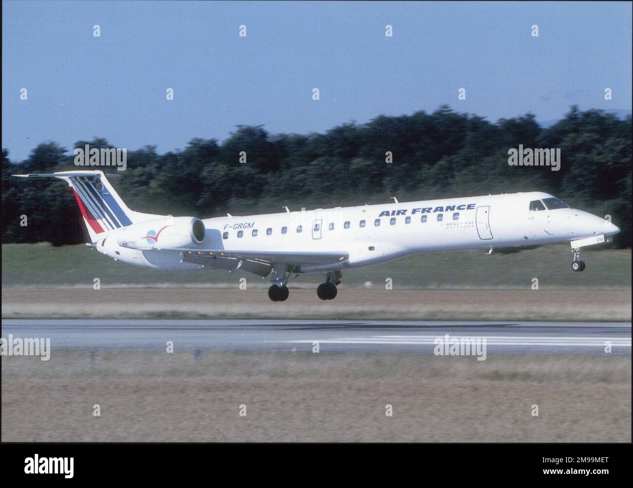 Air France Embraer ERJ-145 sur décollage, côté, nez droit (FGRGM). Embraer S.A. est un conglomérat brésilien de l'aérospatiale qui produit des avions commerciaux, militaires, exécutifs et agricoles et qui fournit des services aéronautiques. Banque D'Images
