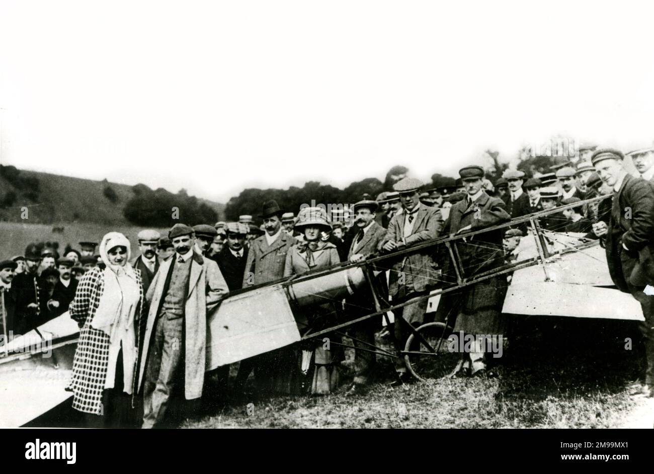 Louis Bleriot, aviateur pionnier légendaire, avec sa femme Alice et une foule de spectateurs, posant avec son avion après avoir effectué le premier vol en avion à travers la Manche, de Calais à Douvres, le 25 juillet 1909. Banque D'Images