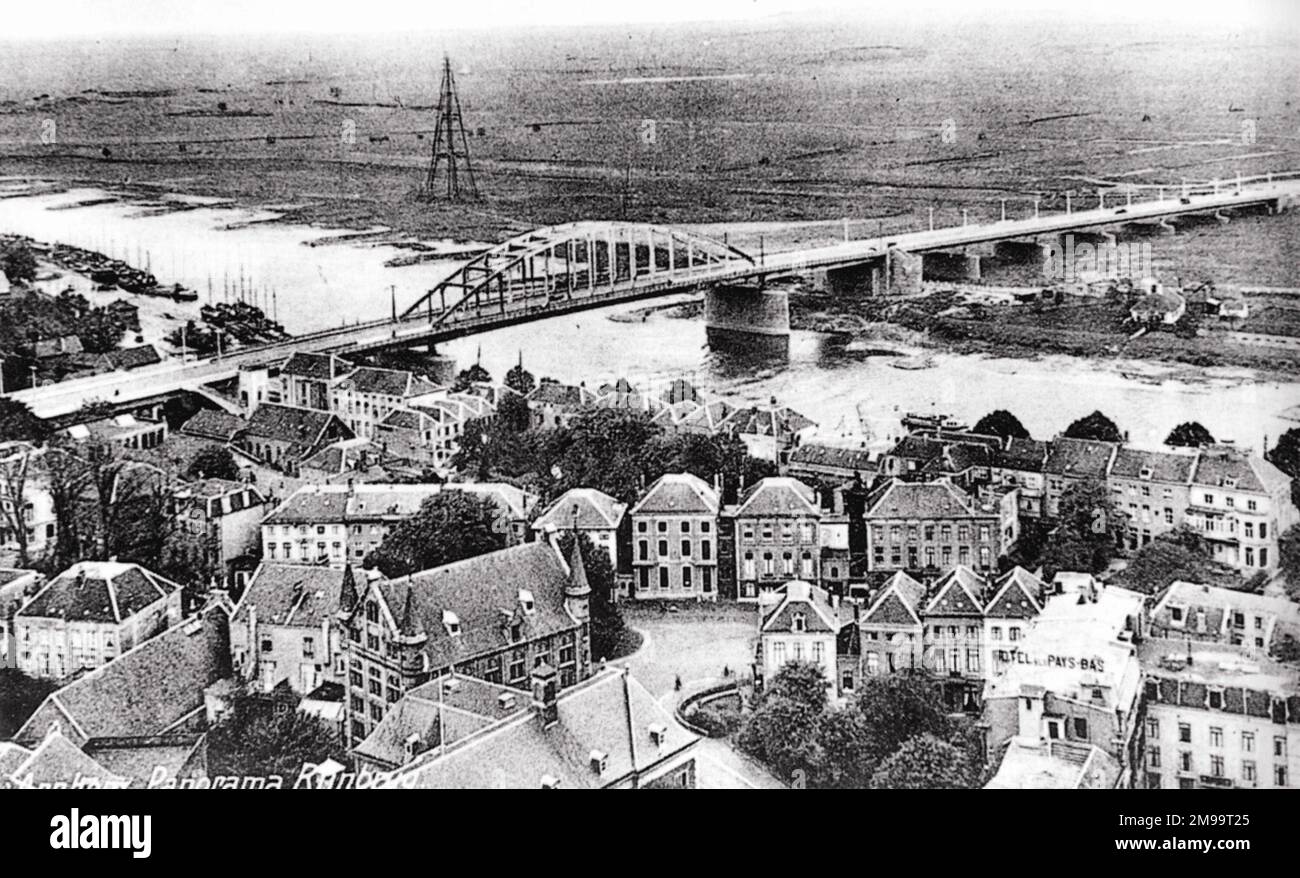 C'est la vue du pont d'Arnhem prise du sommet de l'église Eusebius trois ans après l'ouverture de la première. Entre 1939 et 1950, il a été soufflé et réconstruit plusieurs fois. La vue montre les bâtiments comme ils auraient été pendant les combats de septembre 1944. La vue est du côté Arnhem de la rivière. Quelque 500 hommes du 2nd Bataillon de parachutistes sous le lieutenant-colonel John Frost ont atteint le pont environ 2000 heures le 17 septembre, le premier jour de l'opération. Ils et d'autres comme ils sont arrivés ont occupé les maisons qui ont contiguë aux rampes du pont, leurs étages supérieurs avec l'esprit de niveau Banque D'Images