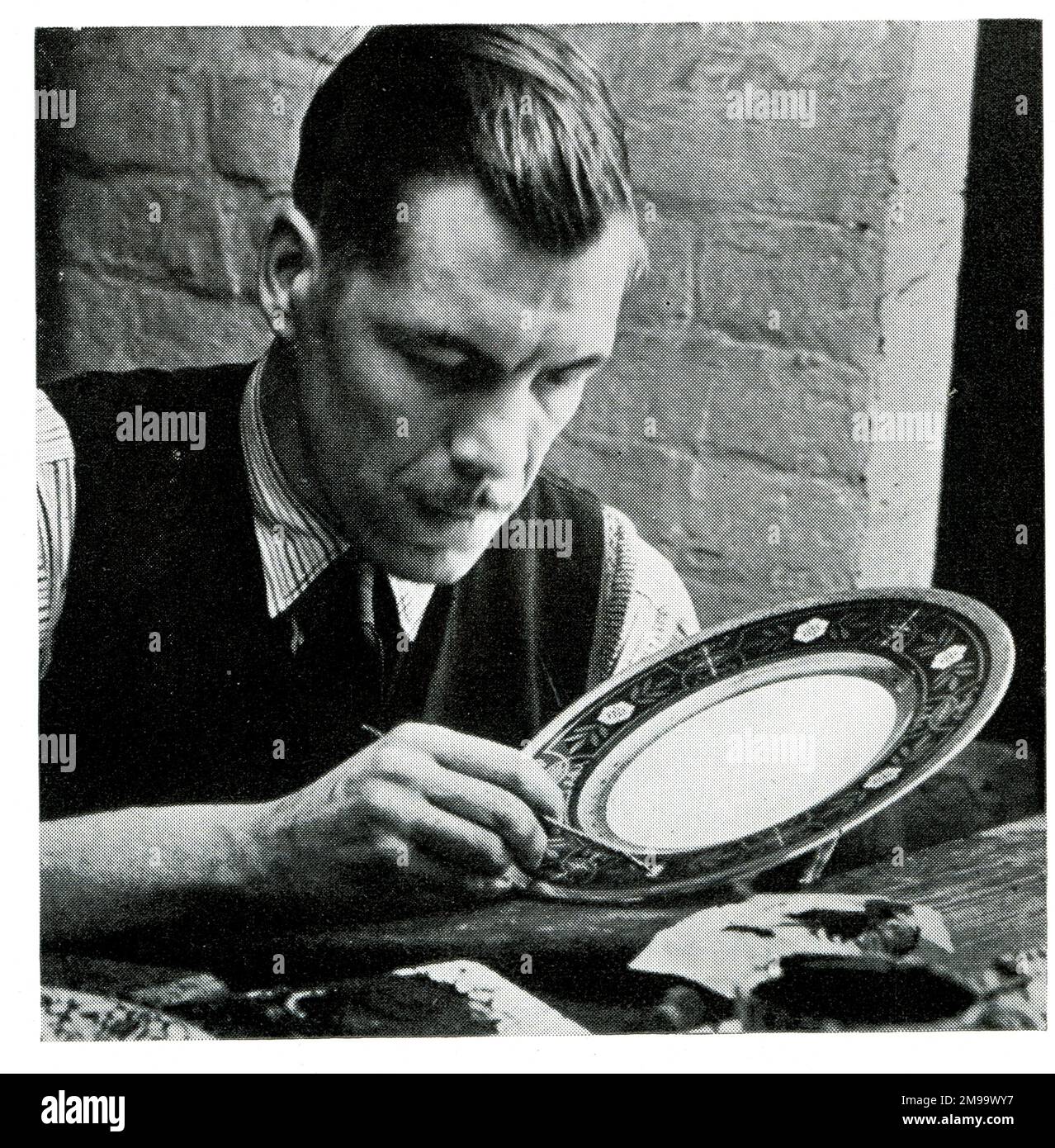 Application de l'or dans la dernière étape de la décoration de chine. Banque D'Images