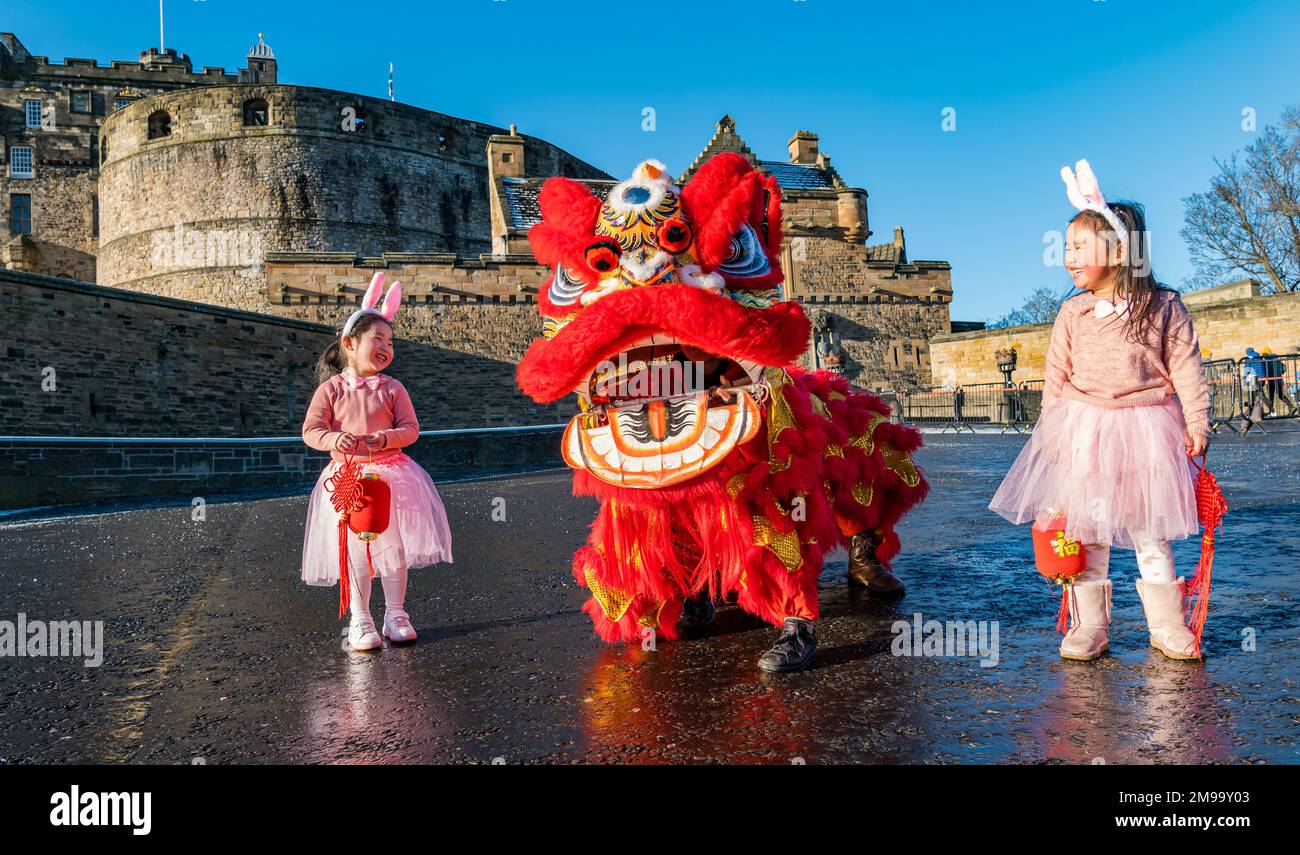 Jeunes filles chinoises portant des oreilles de lapin diverties par des danseurs de dragon pour célébrer le nouvel an chinois, (année du lapin), Château d'Édimbourg, Écosse, Royaume-Uni Banque D'Images
