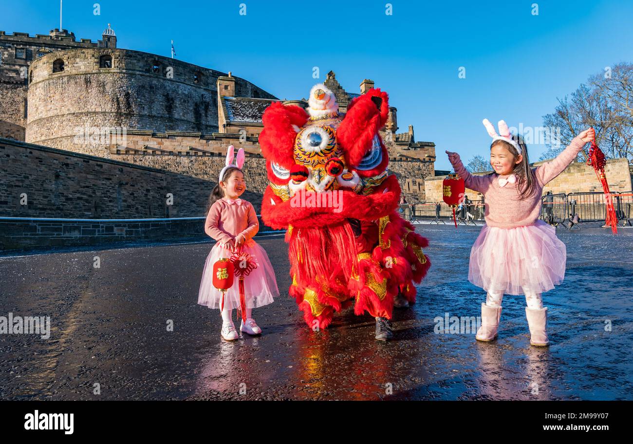 Jeunes filles chinoises portant des oreilles de lapin diverties par des danseurs de dragon pour célébrer le nouvel an chinois, (année du lapin), Château d'Édimbourg, Écosse, Royaume-Uni Banque D'Images