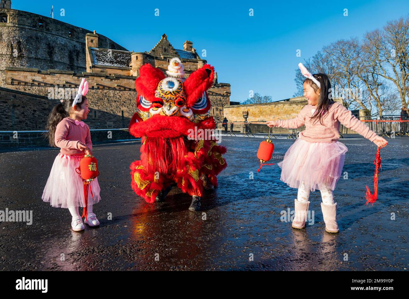 Jeunes filles chinoises portant des oreilles de lapin diverties par des danseurs de dragon pour célébrer le nouvel an chinois, (année du lapin), Château d'Édimbourg, Écosse, Royaume-Uni Banque D'Images