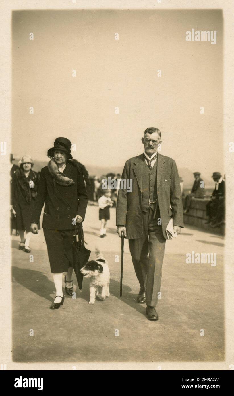 Un couple de personnes âgées (et plutôt poudreux) prend leur chien pour une promenade le long du front de mer à North Bay, Scarborough, North Yorkshire. Je serais un peu surpris si cette photo Candid en particulier a donné lieu à une vente...!! Banque D'Images