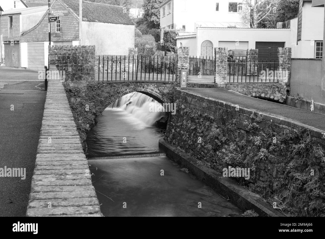 Longue exposition d'un écoulement d'eau sous un pont sur la rivière Lim Walkway à Lyme Regis dans Dorset. Banque D'Images