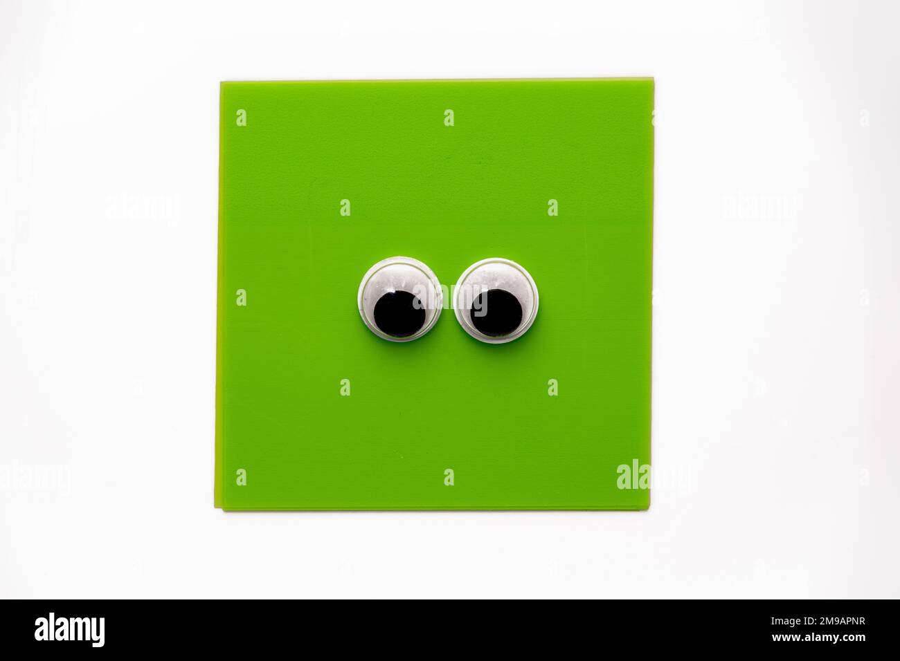 Paire de jolis yeux sur un bloc-notes carré vert isolé sur un fond blanc Banque D'Images