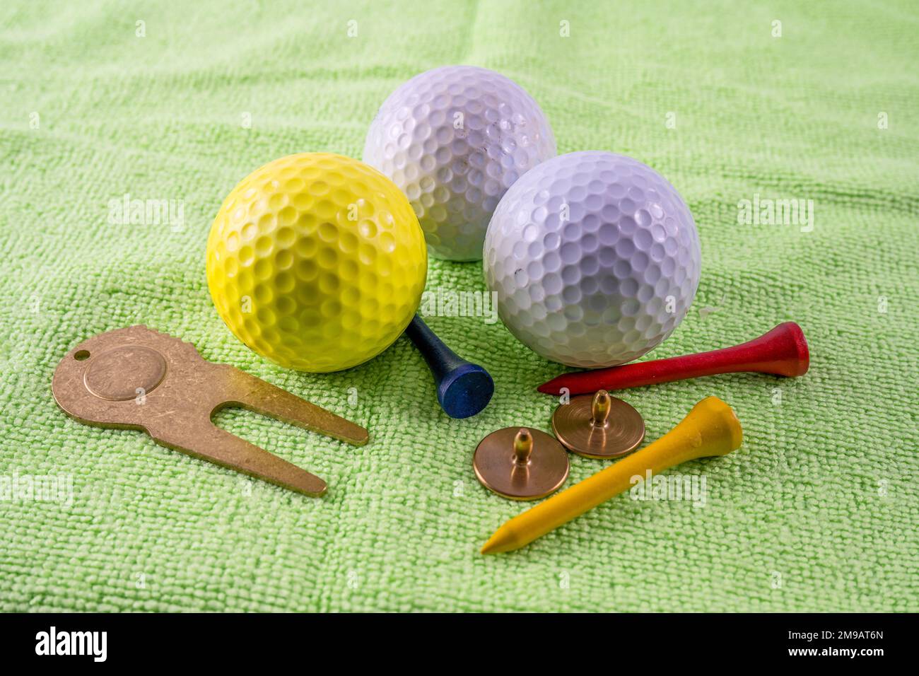 accessoires de golf essentiels marqueurs de balle de haute qualité et réparateur de divet avec balles et tees sur un tapis de pratique de mise en place à l'intérieur Banque D'Images