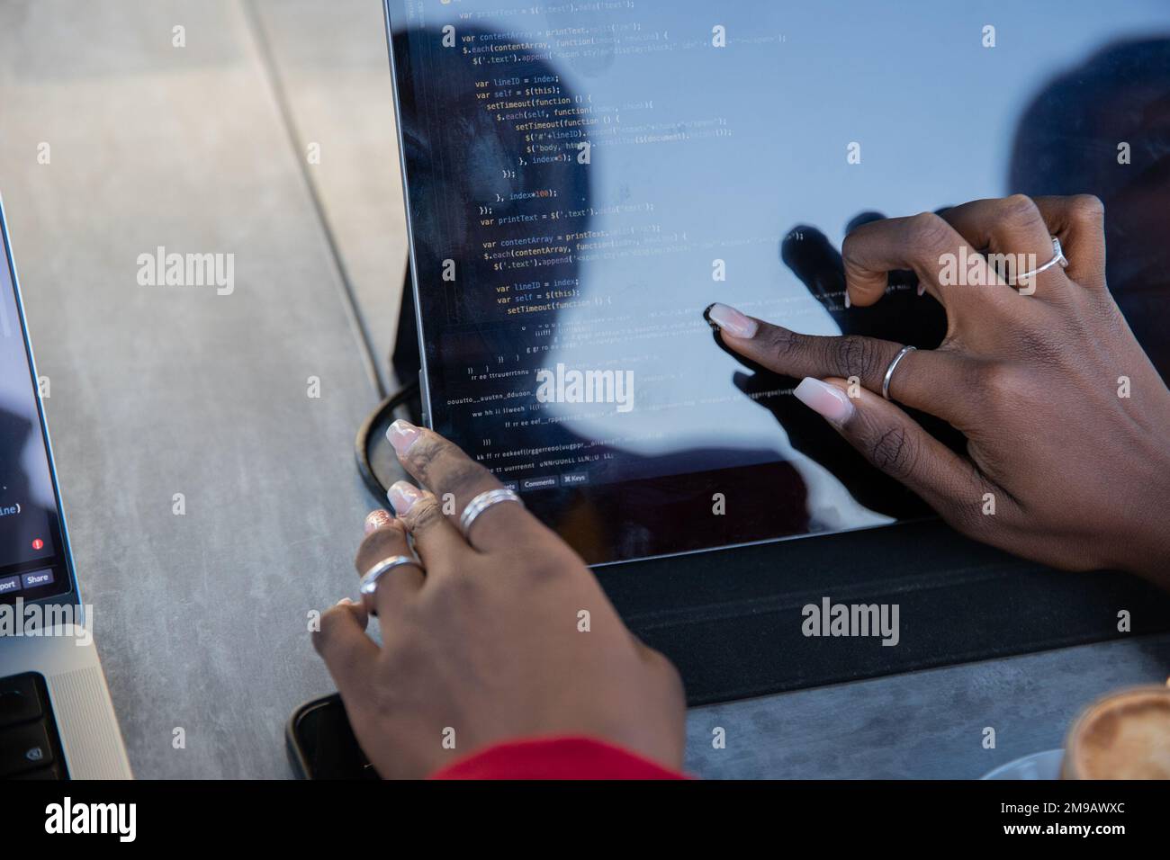 Une femme africaine programmeuse écrit du code sur sa tablette Banque D'Images