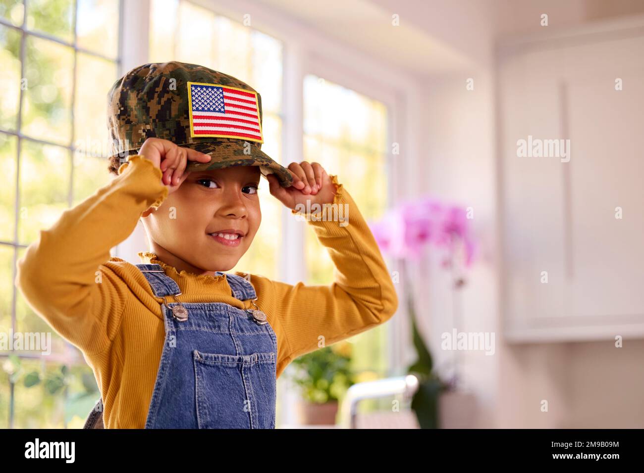 Portrait de la jeune fille portant la casquette américaine de parent dans  la cuisine à la maison Photo Stock - Alamy
