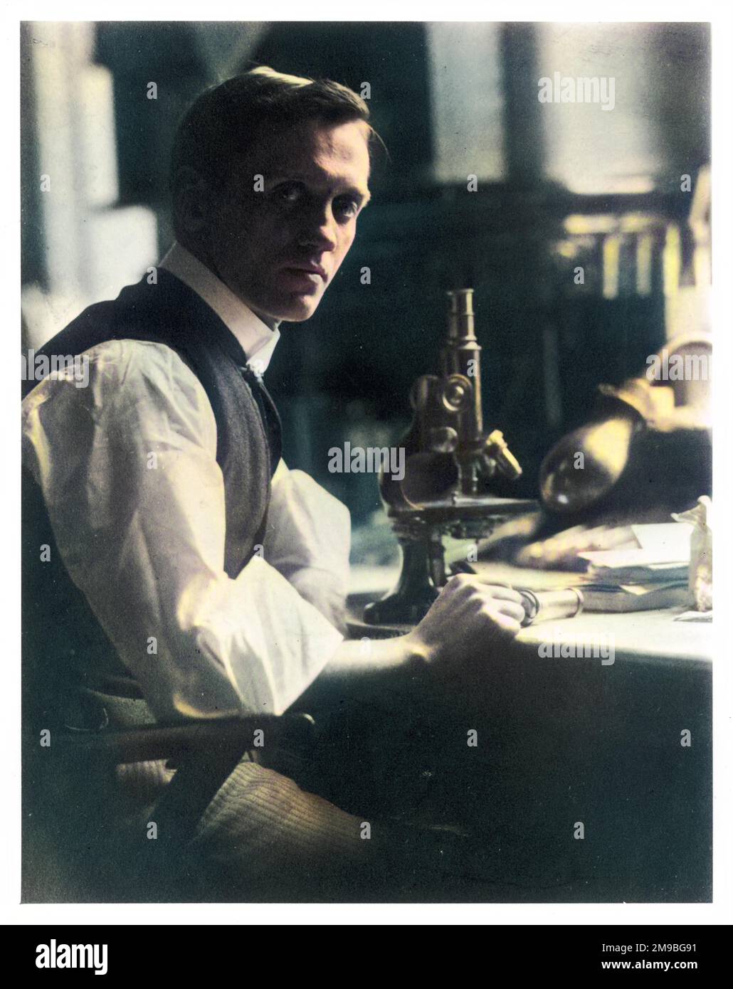 SIR ALEXANDER FLEMING (1881 - 1955), bactériologue écossais à son bureau avec son microscope. Banque D'Images