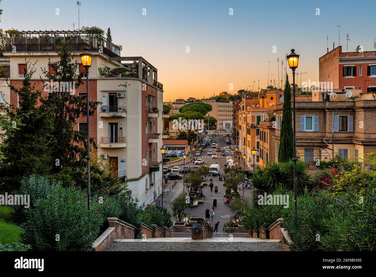 Vue sur les escaliers dans le parc urbain, les lampadaires et les bâtiments résidentiels dans la soirée à Rome, Italie. Banque D'Images