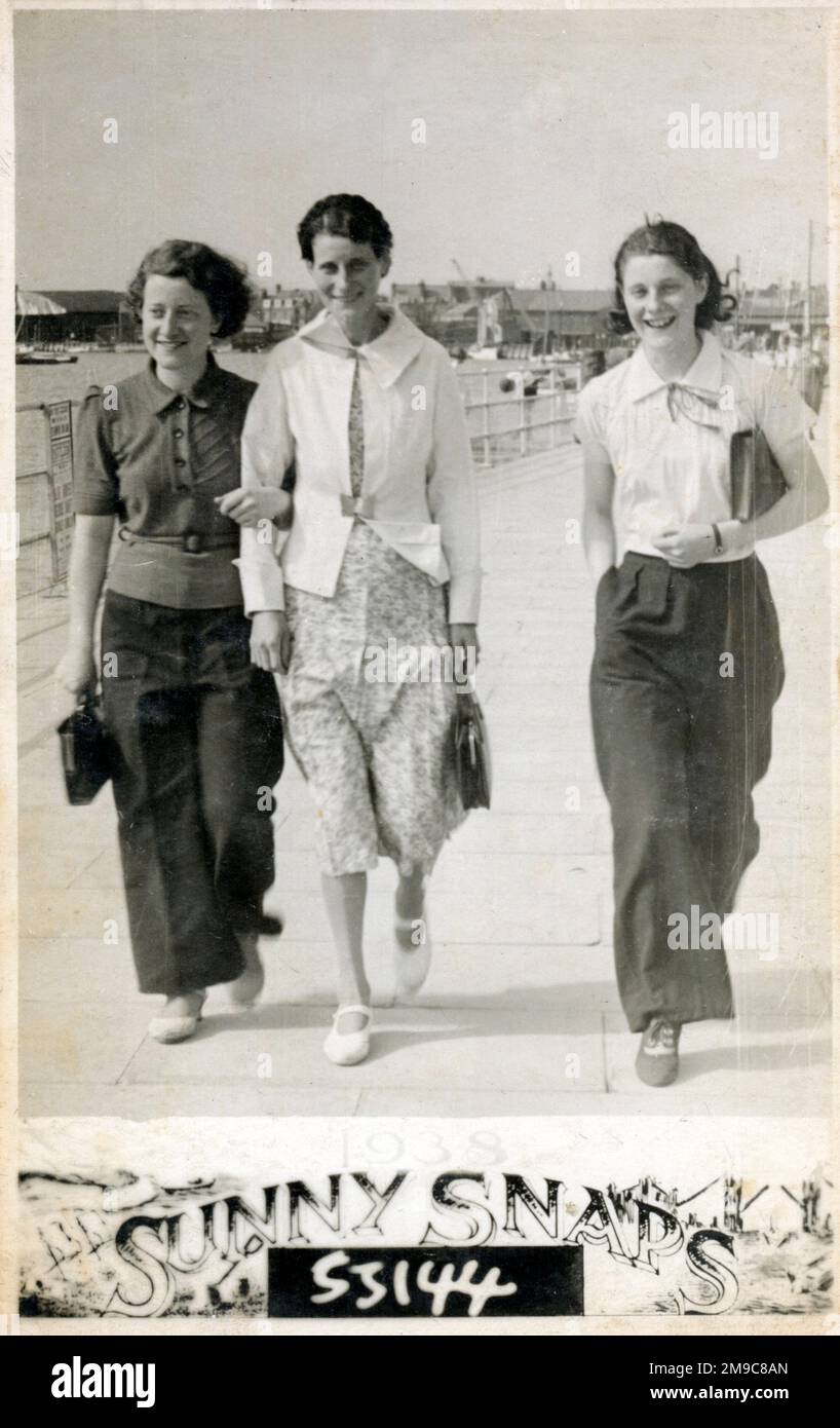 Trois jeunes femmes se promenant le long du front de mer d'une station côtière britannique en été. Banque D'Images