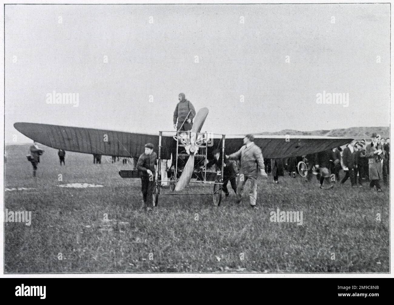 A 3 heures du matin Louis Blériot, aviateur français, debout au centre de son avion 'Blériot XI' aux Barraques (près de Calais). L'avion de Bleriot conçu et construit par lui-même, longeant le sol pendant cinquante mètres avant d'embarquer pour le vol à travers la Manche à destination de Douvres. Banque D'Images