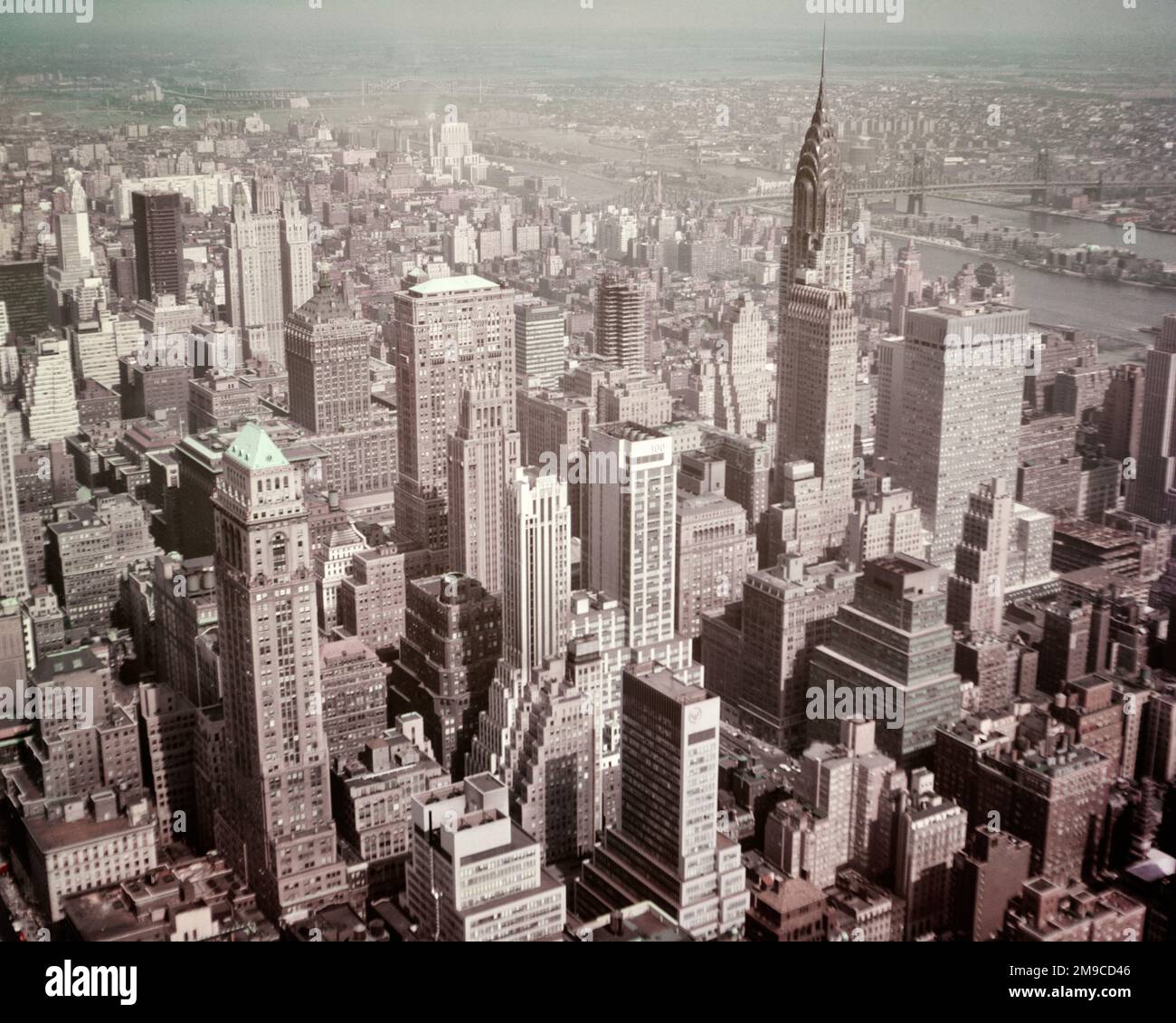 1950S VUE EN HAUTEUR DU QUARTIER EST DE MIDTOWN MANHATTAN AVEC VUE SUR LE BÂTIMENT SPIRE OF CHRYSLER ET SUR EAST RIVER ET LE PONT QUEENSBORO - KR132341 CPC001 HARS NEW YORK QUEENSBORO EAST RIVER OLD FASHIONED SPIRE Banque D'Images
