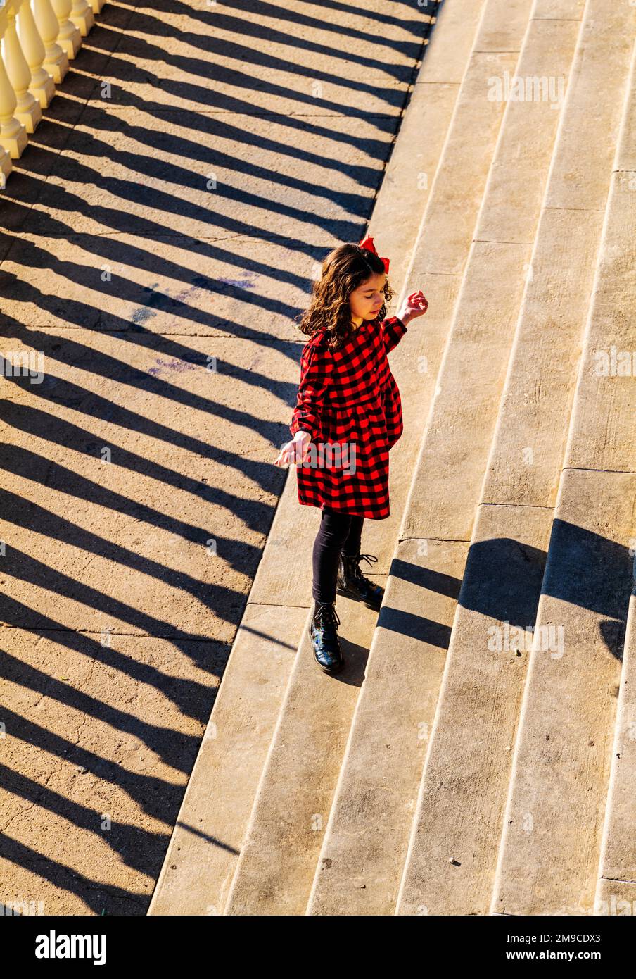 Une jeune fille sautait joyeusement le long d'un sentier de pierre éclairé par le soleil; Fairmount Water Works; Philadelphie; Pennsylvanie; États-Unis Banque D'Images