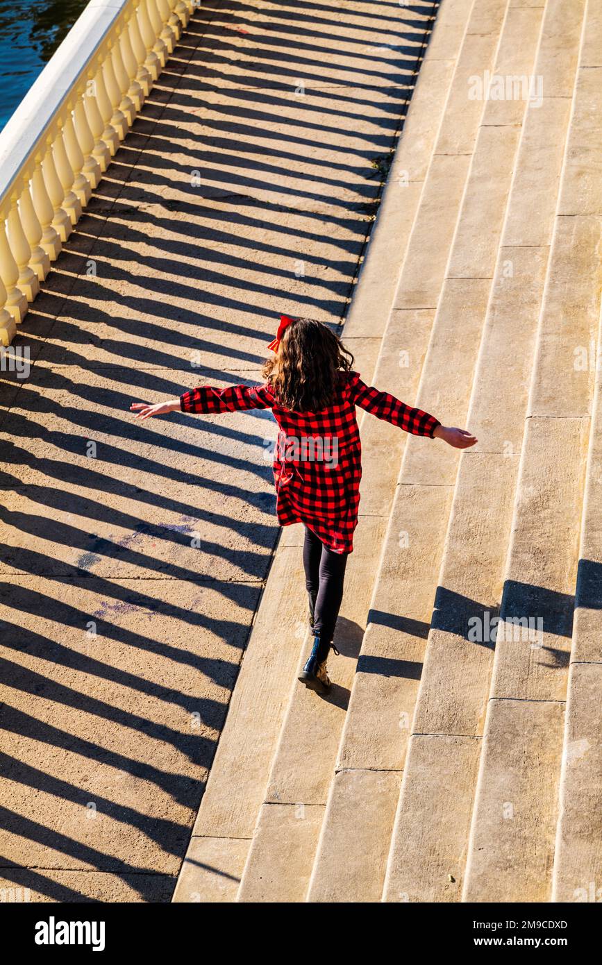 Une jeune fille sautait joyeusement le long d'un sentier de pierre éclairé par le soleil; Fairmount Water Works; Philadelphie; Pennsylvanie; États-Unis Banque D'Images