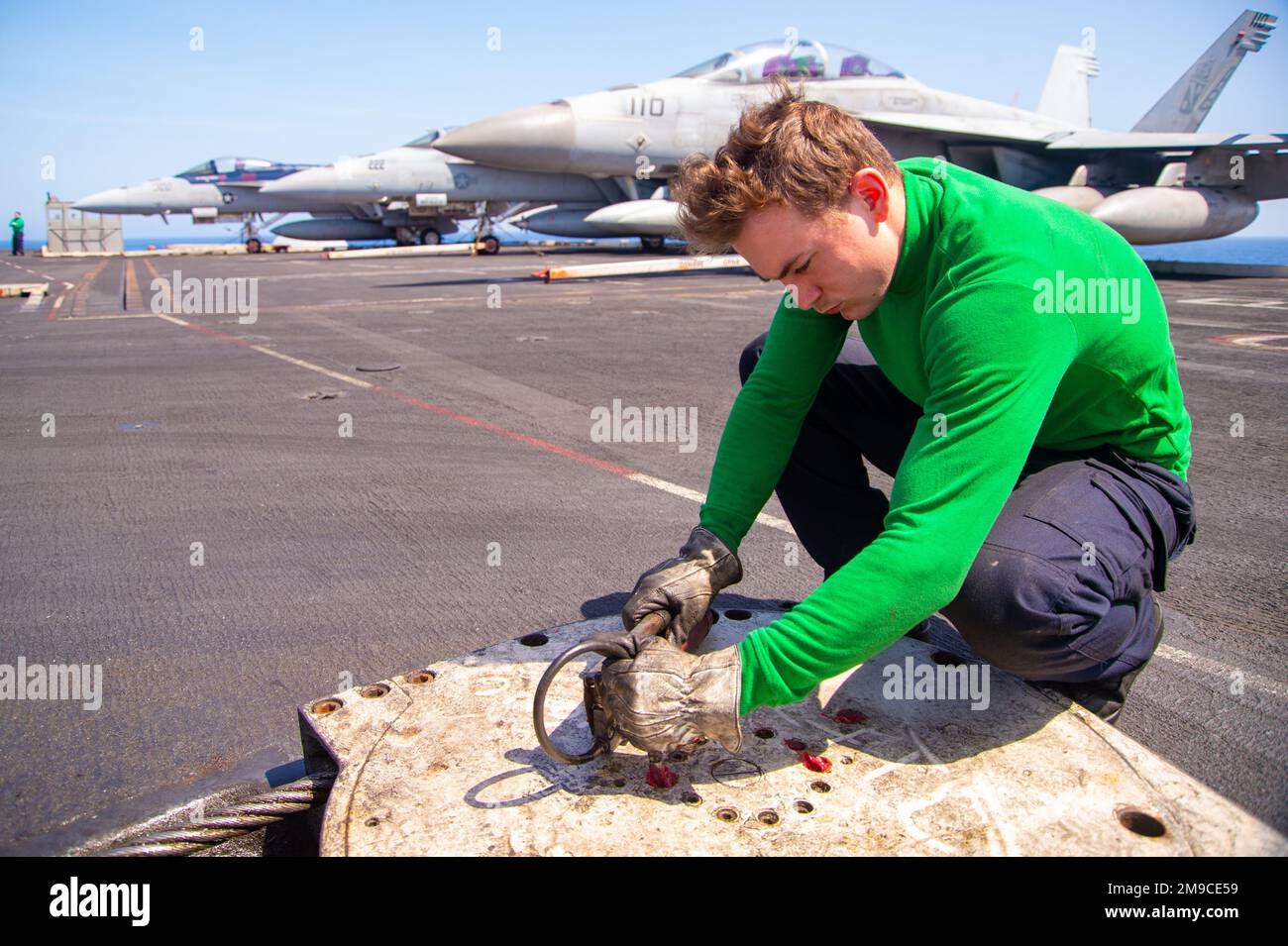 220516-N-TO573-1067 MER TYRRHÉNIENNE (16 mai 2022) l'avionneur Jeremy Taylor, de Sardis, Mississippi, graisse les raccords de boulons sur une poulie rétractable sur le plateau de vol du porte-avions de la classe Nimitz USS Harry S. Truman (CVN 75), 16 mai 2022. Le groupe de grève des transporteurs Harry S. Truman est en cours de déploiement aux États-Unis Sixième zone d'exploitation de la flotte à l'appui des intérêts des États-Unis, des alliés et des partenaires en Europe et en Afrique. Banque D'Images