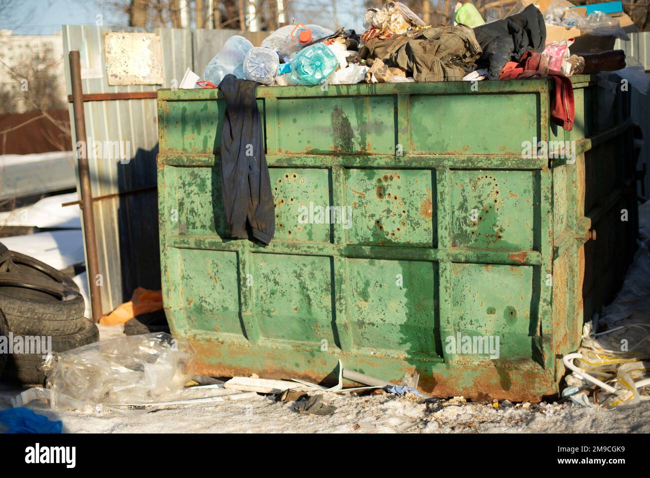 Vidage en ville. Grand conteneur à ordures vert. Beaucoup de déchets. Banque D'Images