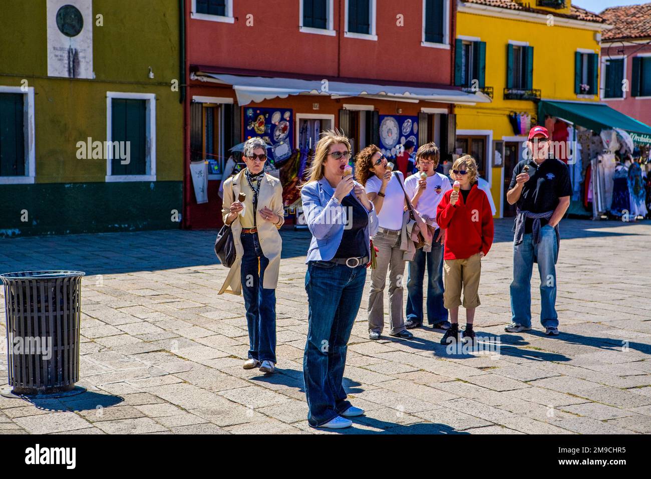 Un groupe de six touristes s'arrêtent et mangent de la glace et de la glace dans le village pittoresque de Bruano, en Italie. Banque D'Images