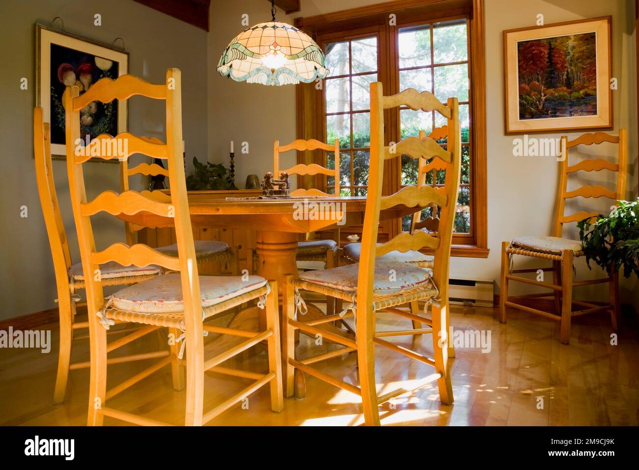 Table de petit déjeuner ronde en bois avec chaises à dossier haut dans la salle de cuisine à l'intérieur de la maison en rondins de style Canadiana. Banque D'Images
